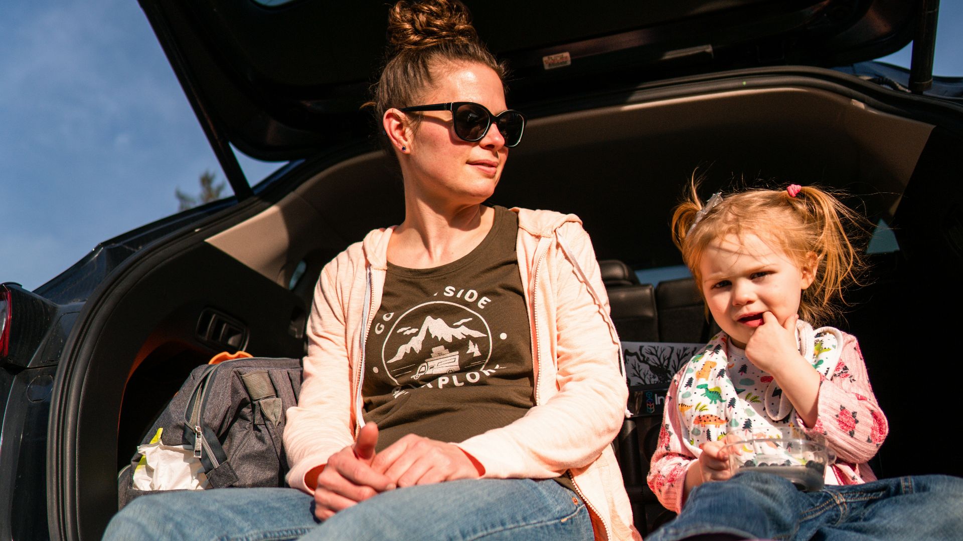woman in black crew neck t-shirt and blue denim jeans sitting on car seat
