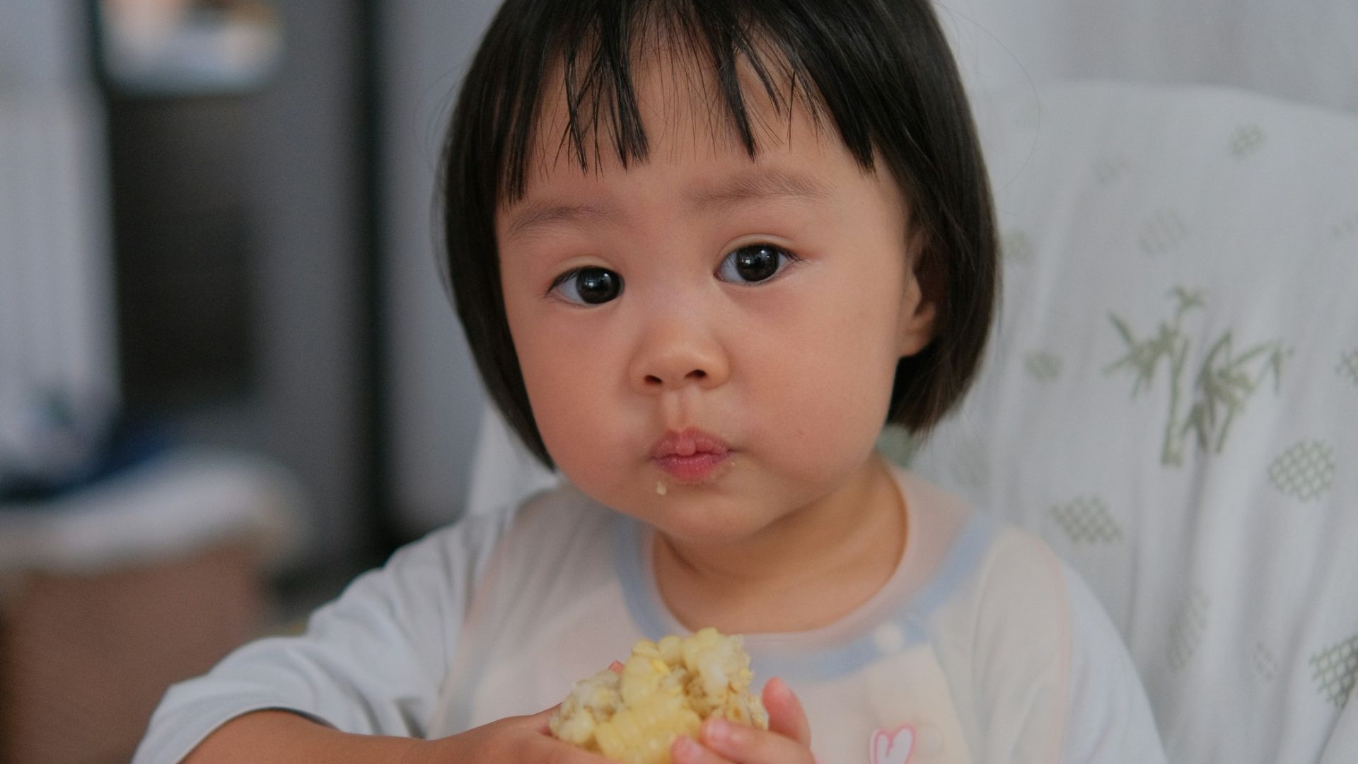 A little girl sitting at a table eating food