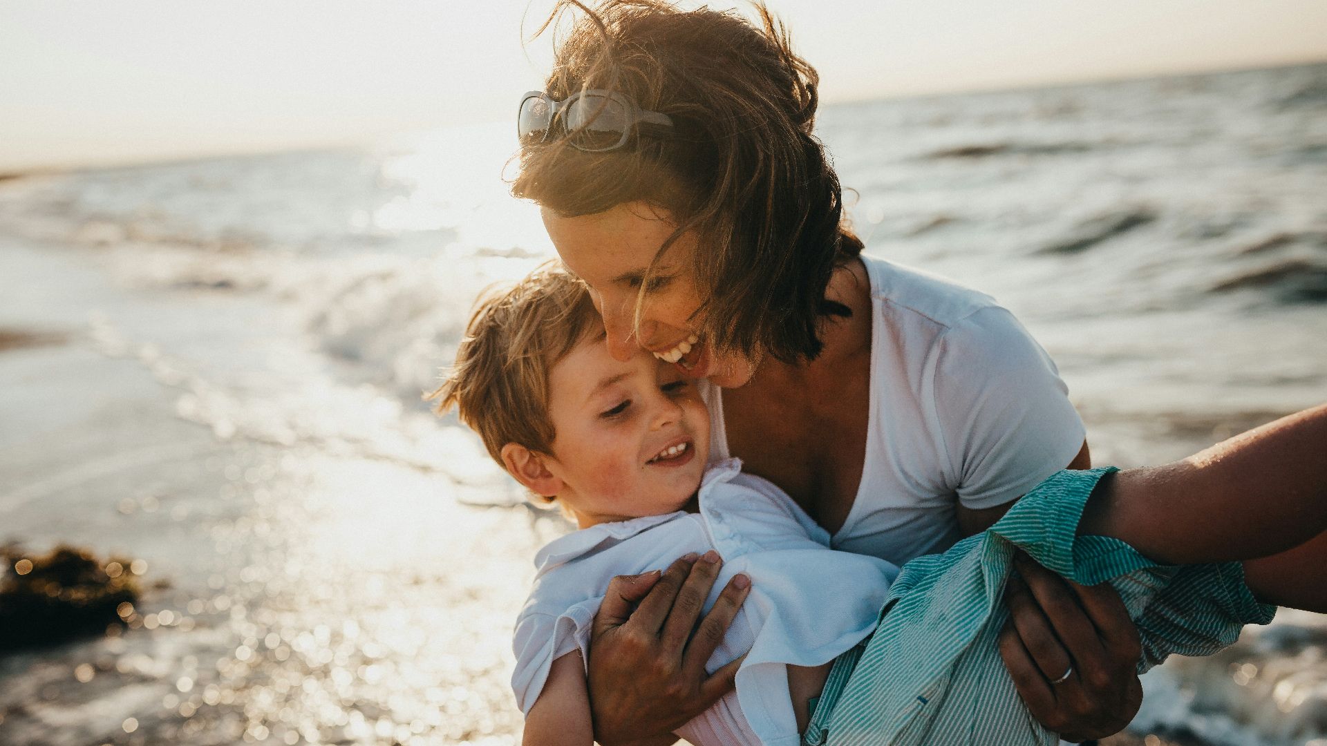 photo of mother and child beside body of water
