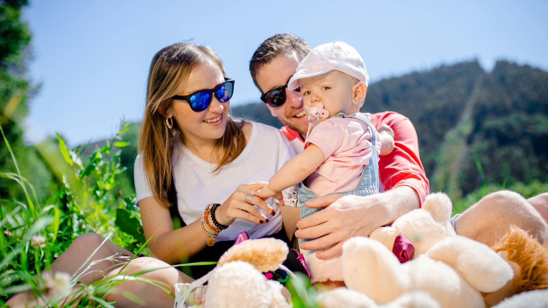 woman in white shirt carrying baby in white and red stripe shirt