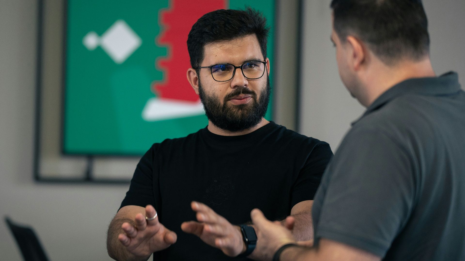 A group of men standing around each other in a room