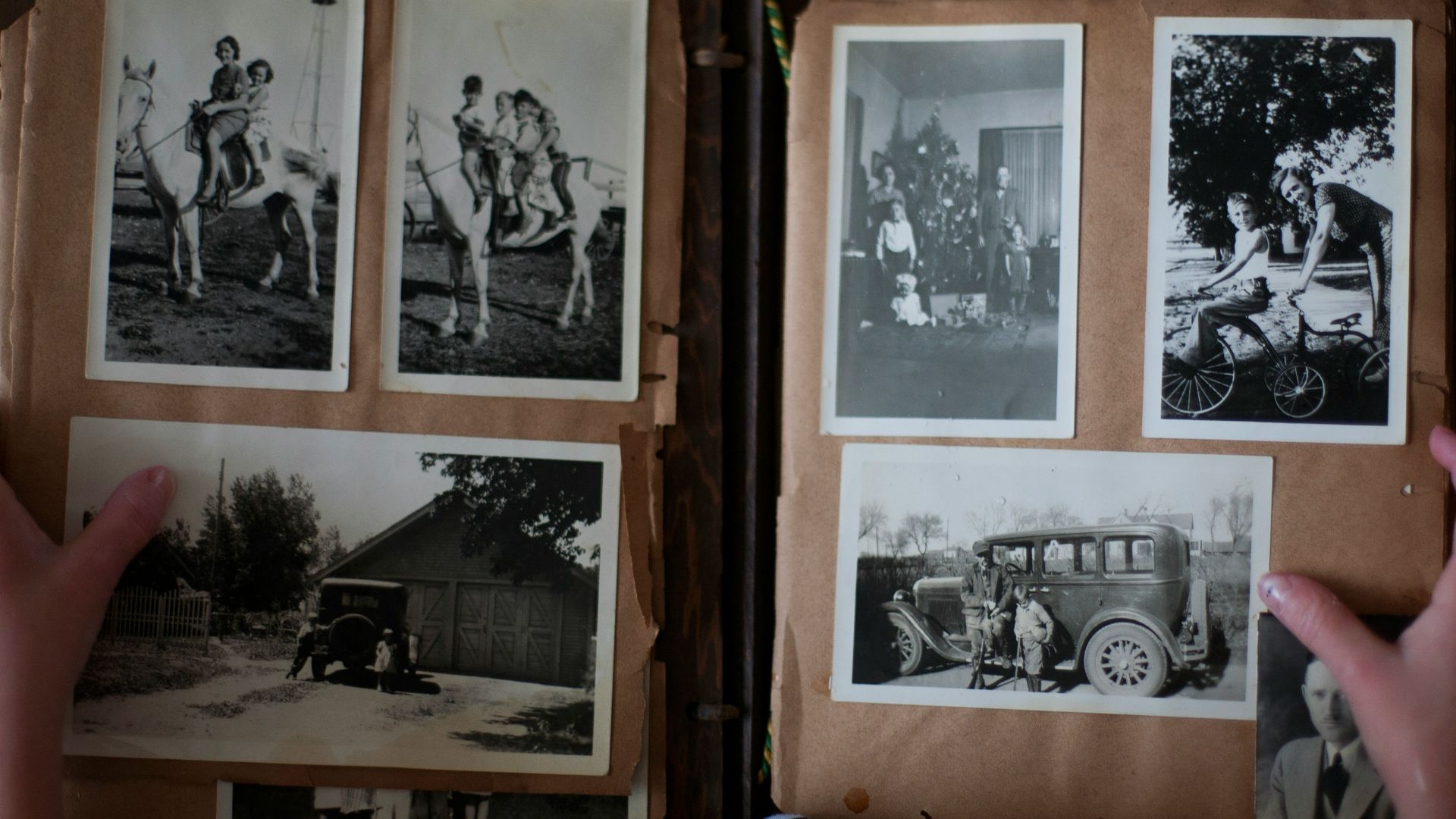 person opening photo album displaying grayscale photos