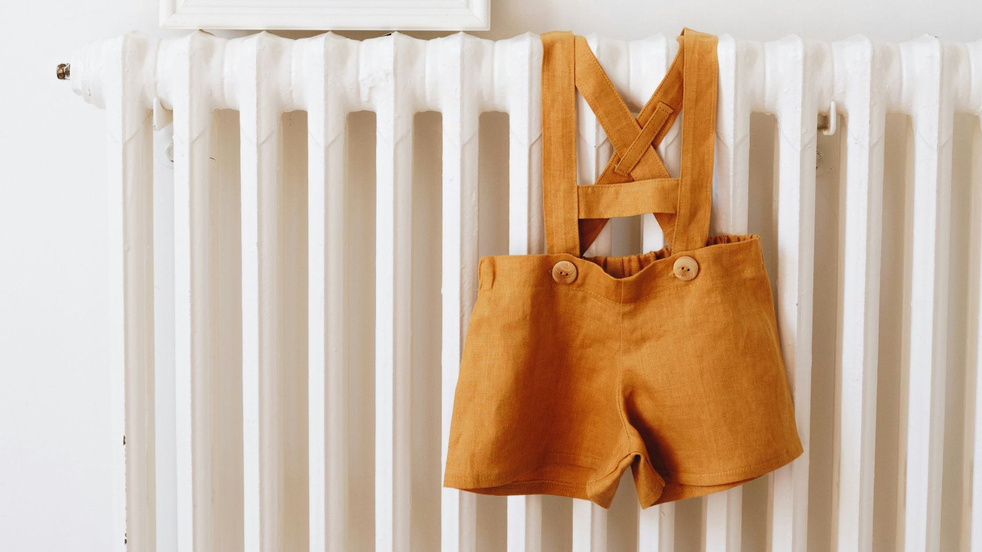 a baby's clothes hanging on a radiator