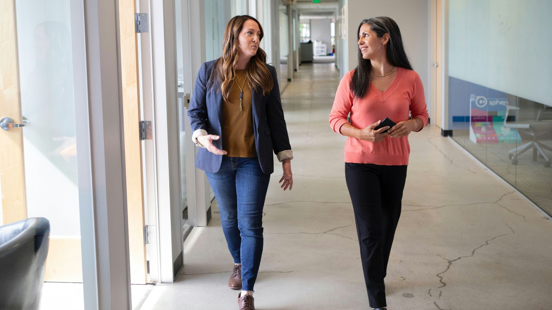 2 women standing near white wall