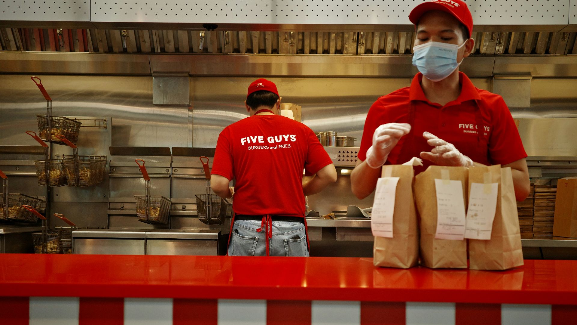 A man wearing a face mask standing behind a counter