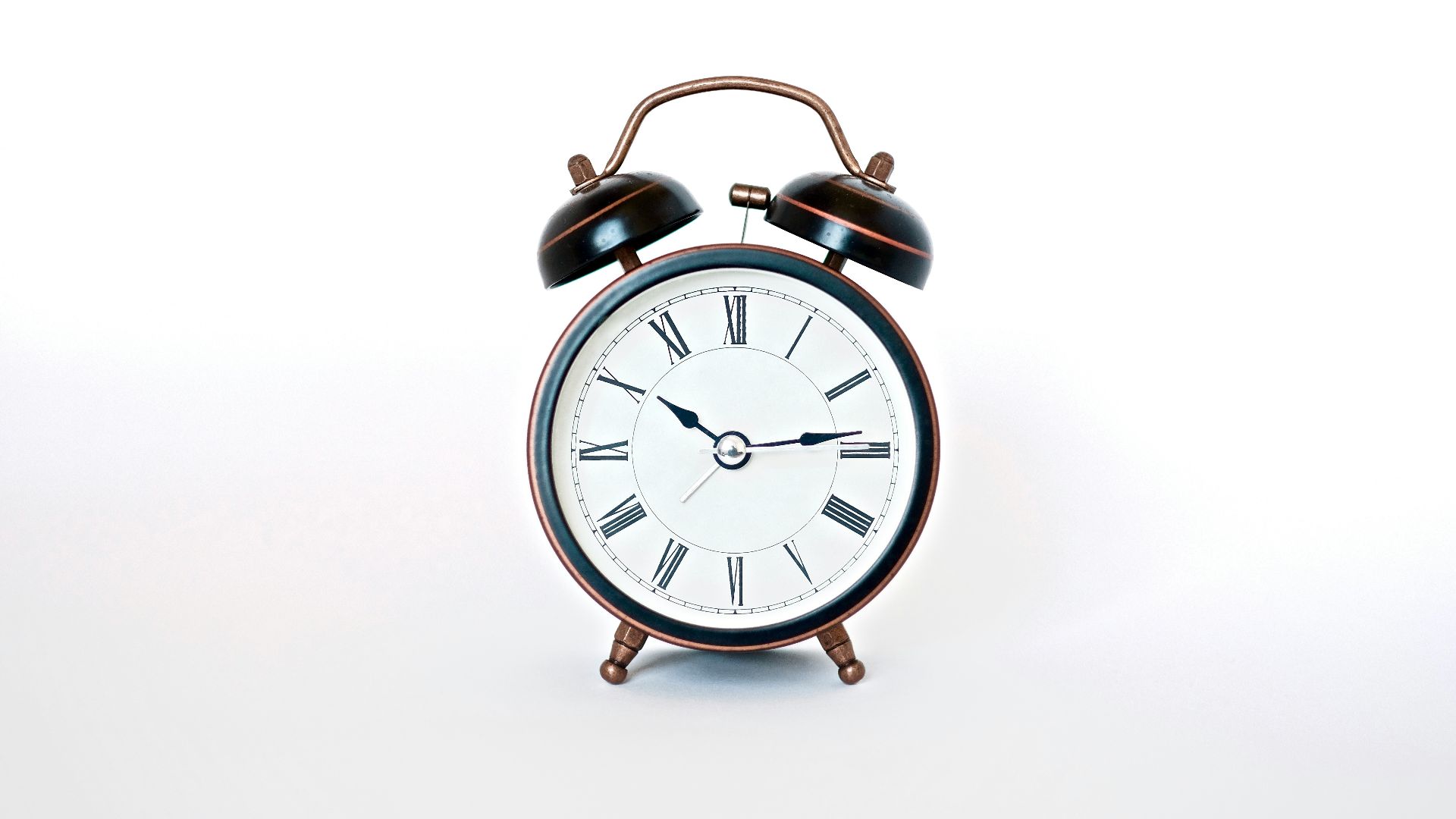 round black and white analog alarm clock