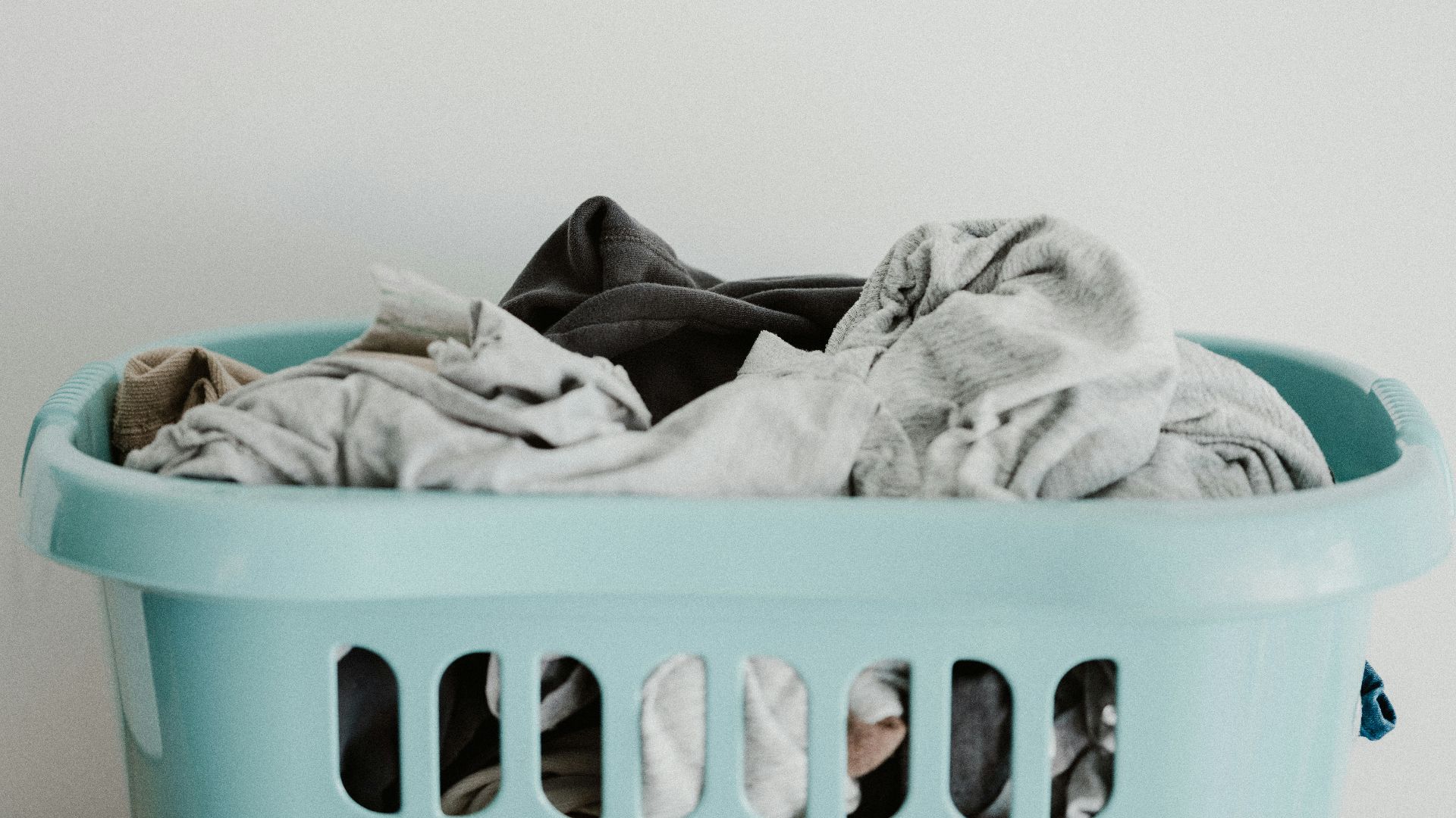 white textile on blue plastic laundry basket