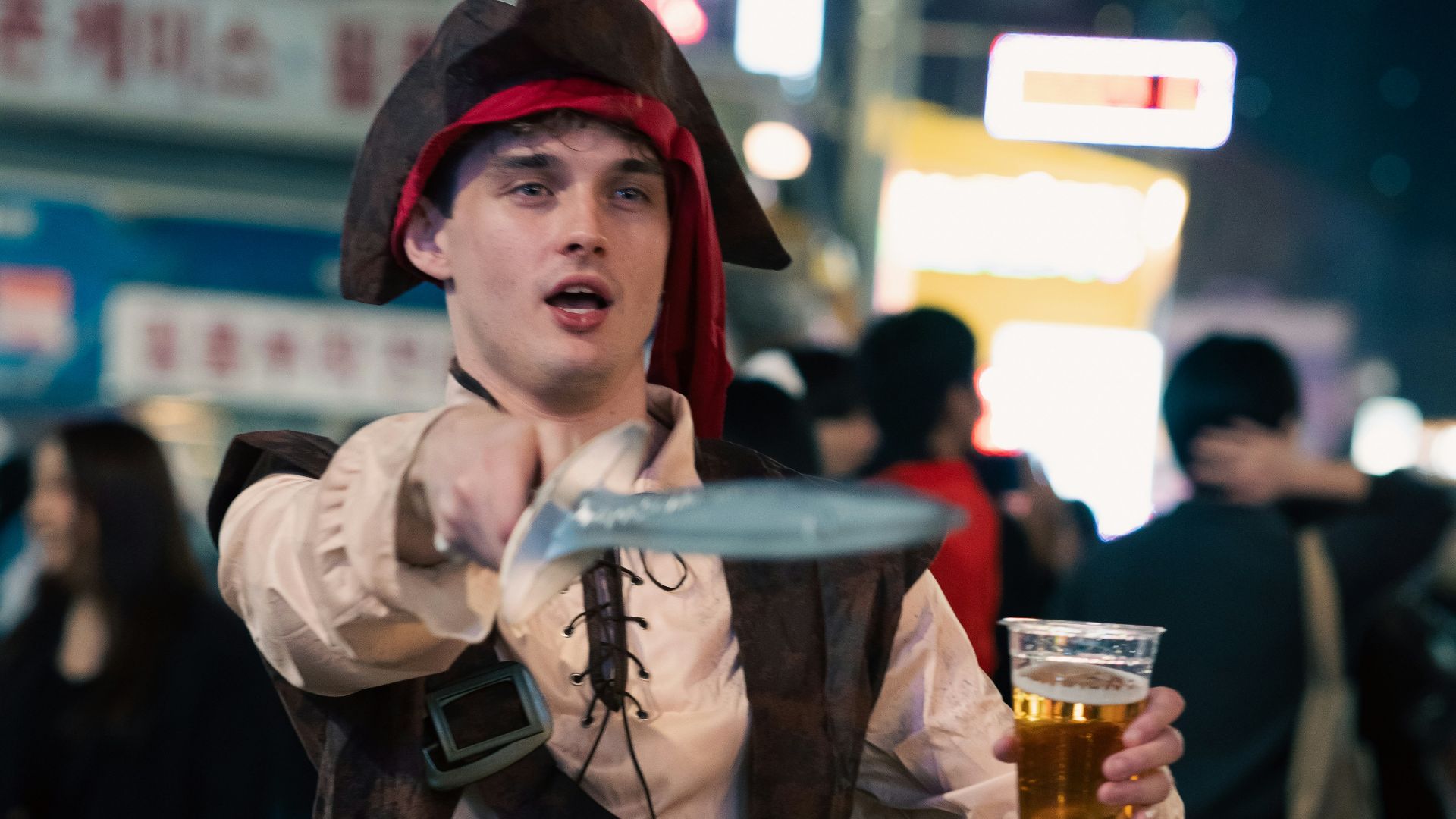 a man in a pirate costume holding a glass of beer