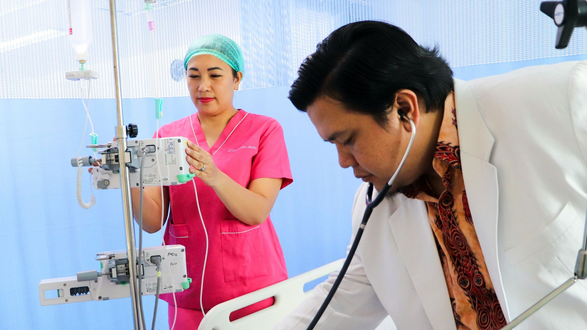 a man laying in a hospital bed being examined by a nurse