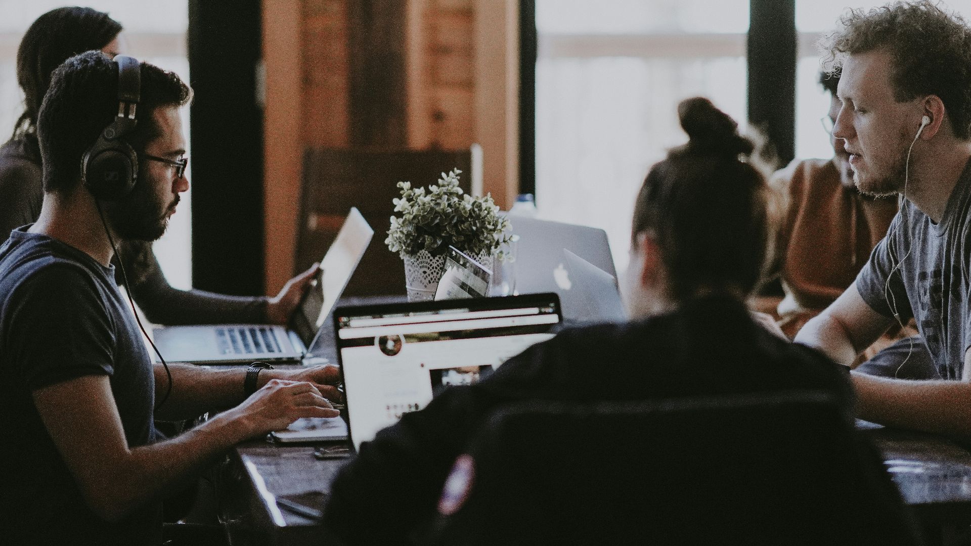 selective focus photography of people sits in front of table inside room