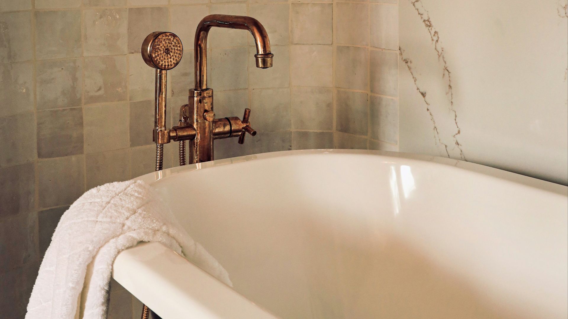 white ceramic bathtub with stainless steel shower head