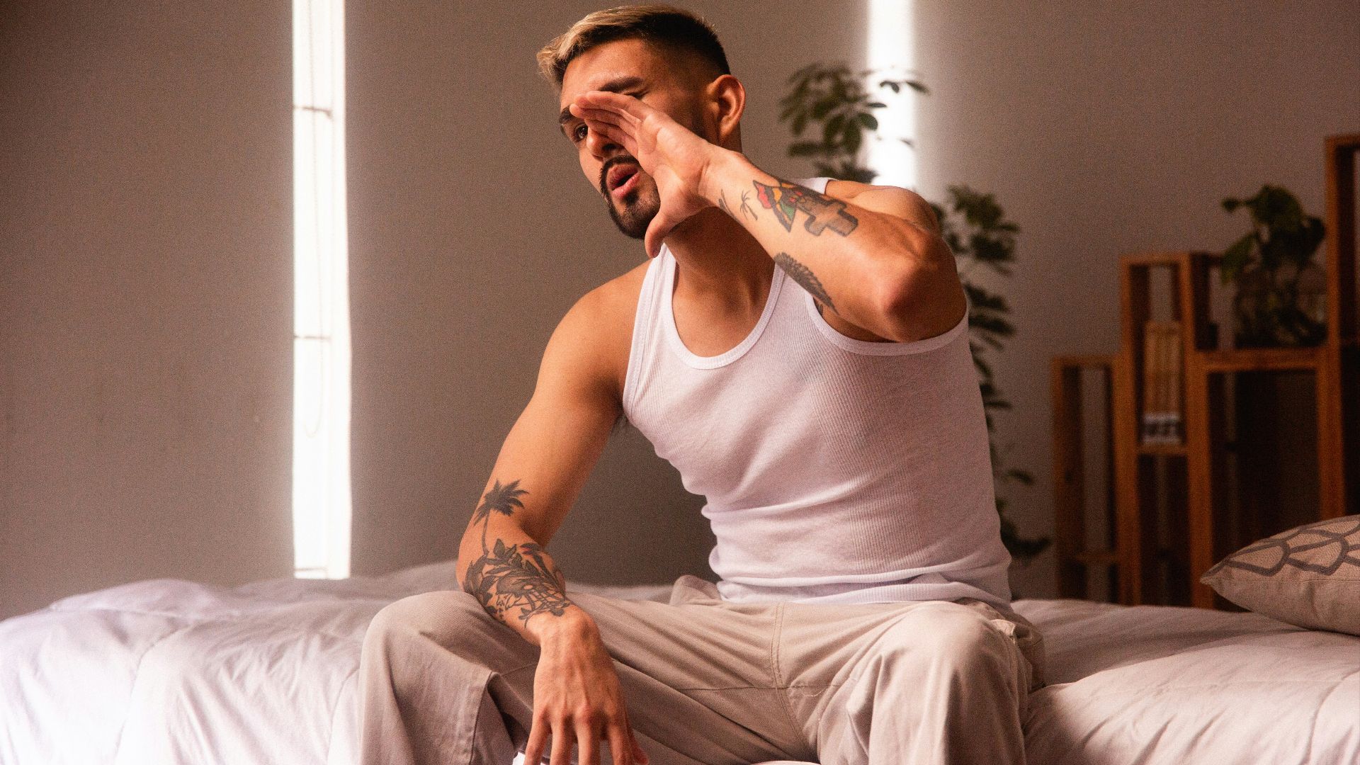 a man sitting on top of a bed in a room