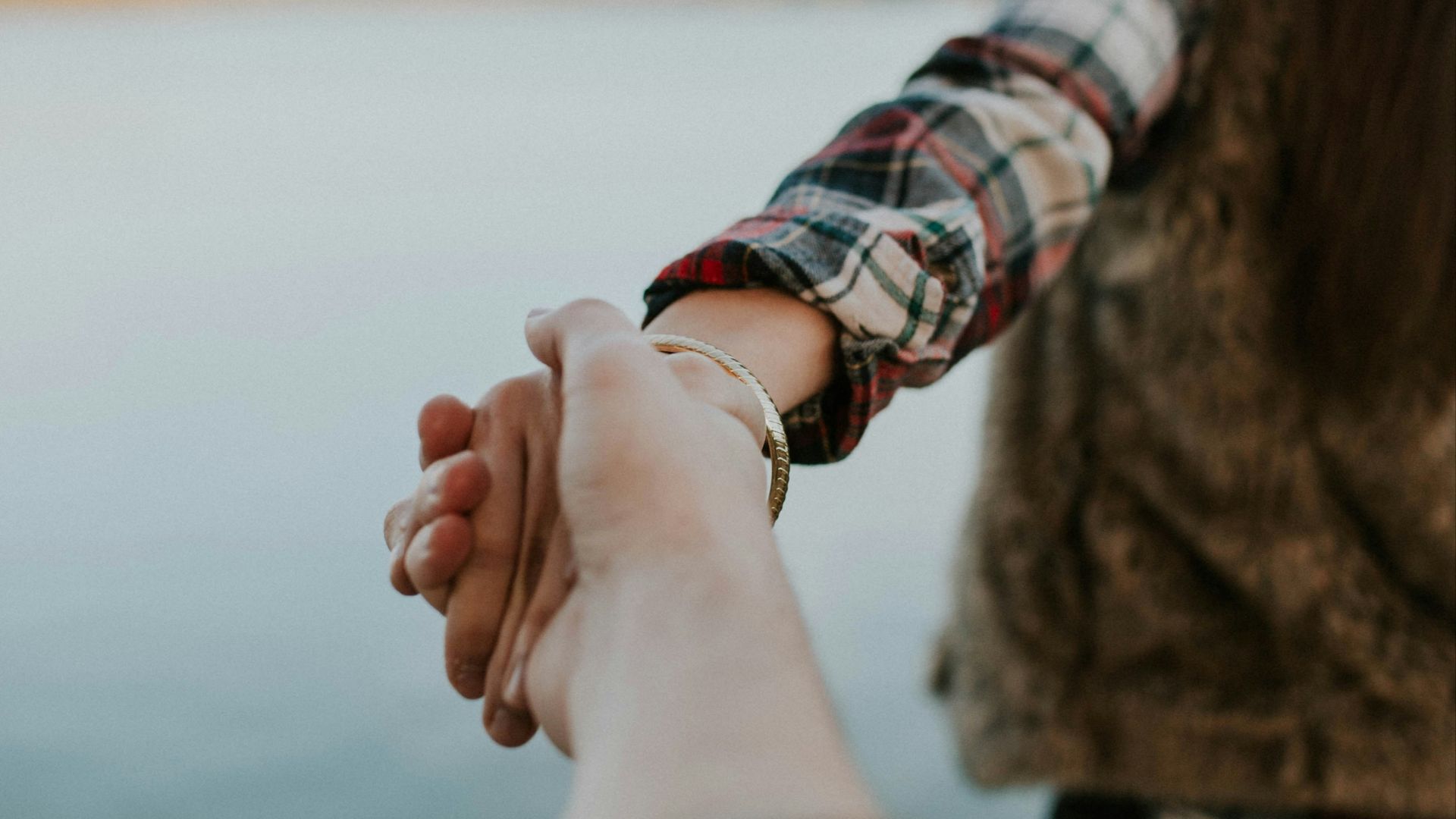 shallow focus photography of man and woman holding hands