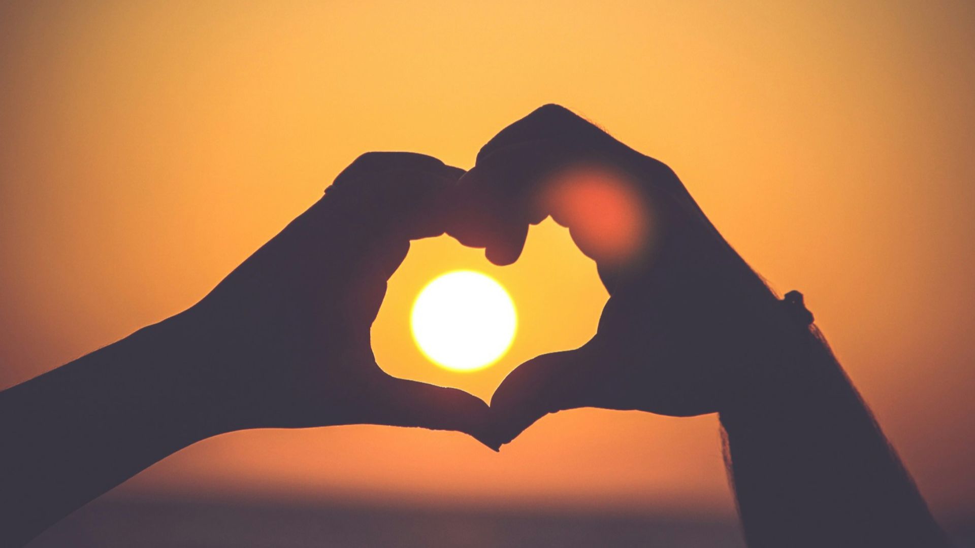 silhouette of person's hands forming heart