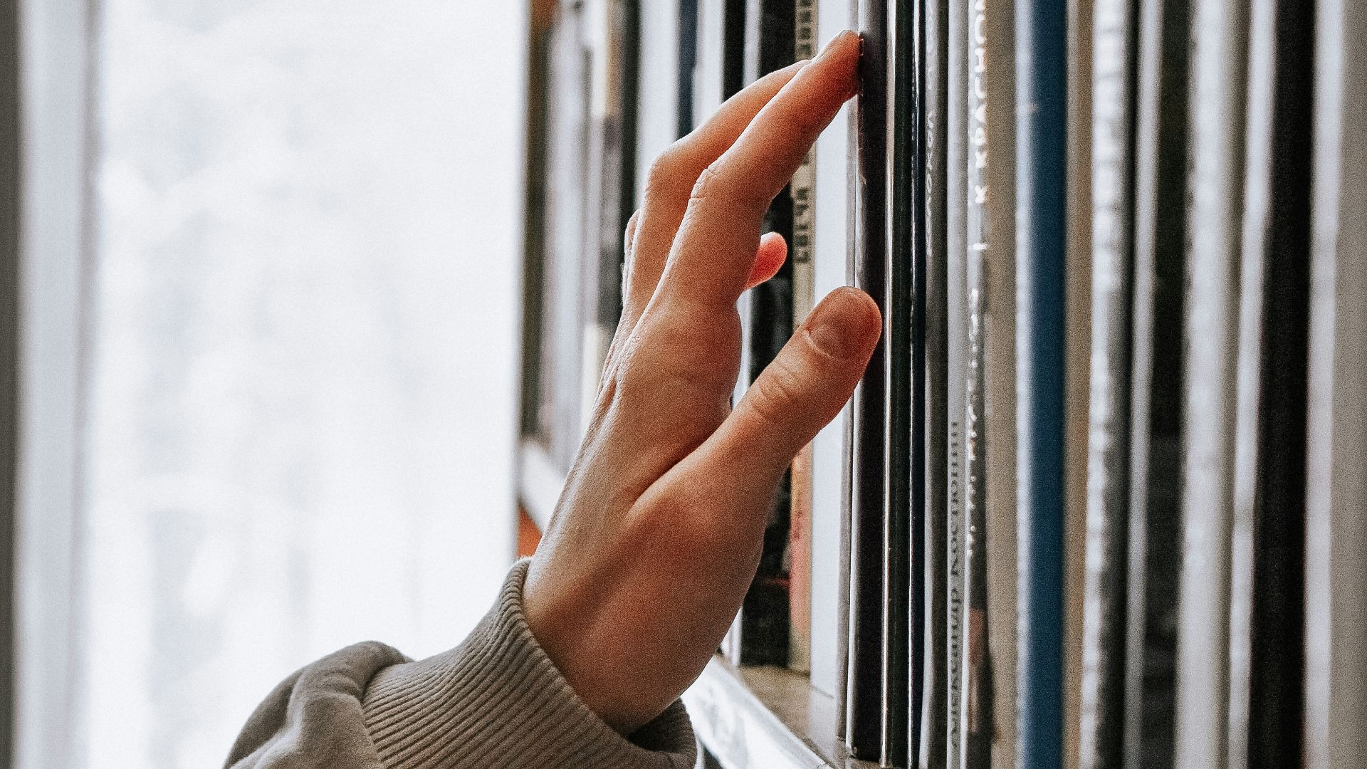 person in white long sleeve shirt holding white book