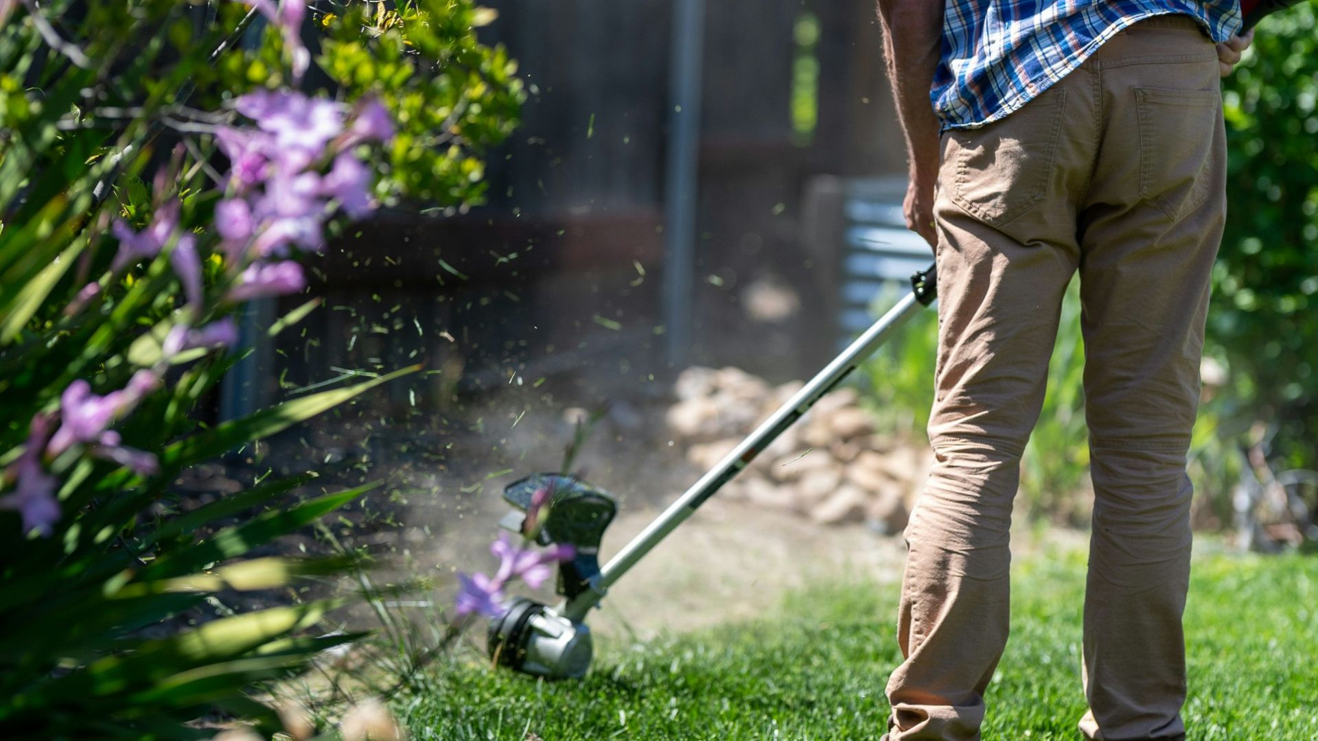a man using a lawn mower to cut grass