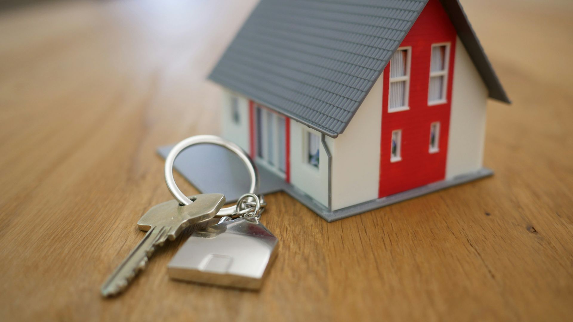 white and red wooden house miniature on brown table