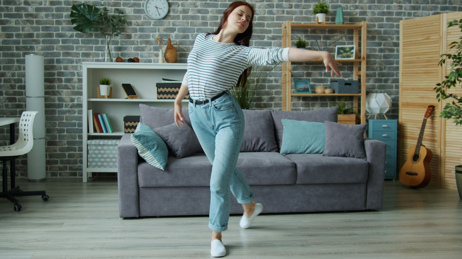 Young woman dancing in a modern living room.