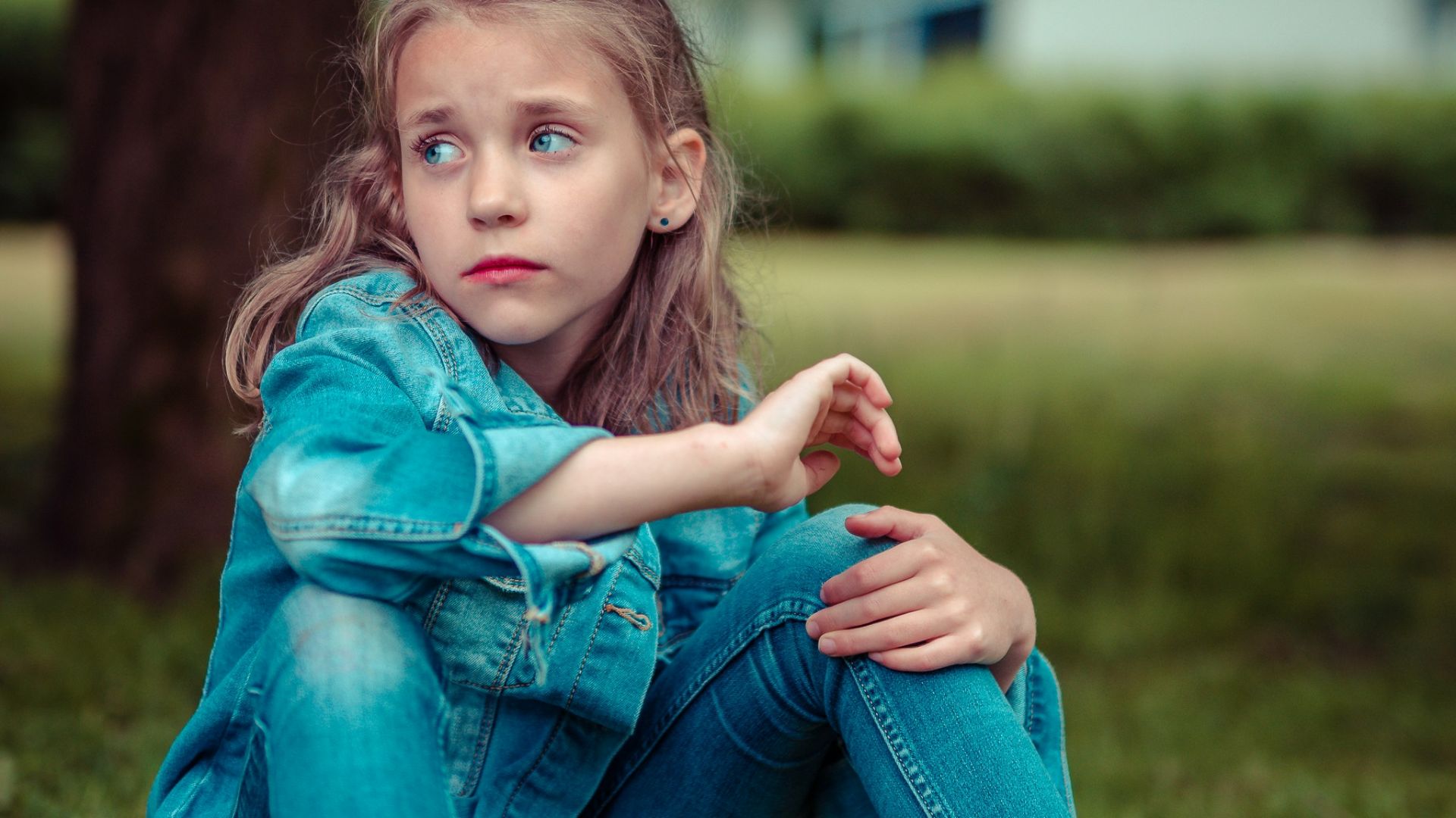 selective focus photography of girl sitting near tree