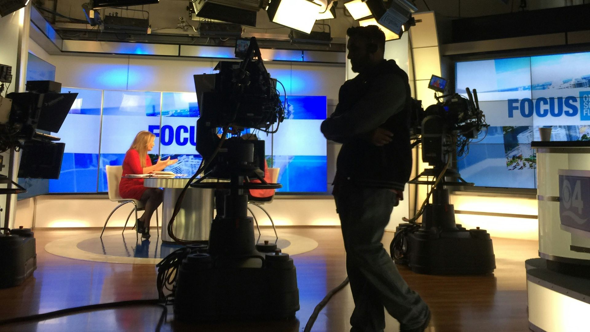 man in black suit standing on stage