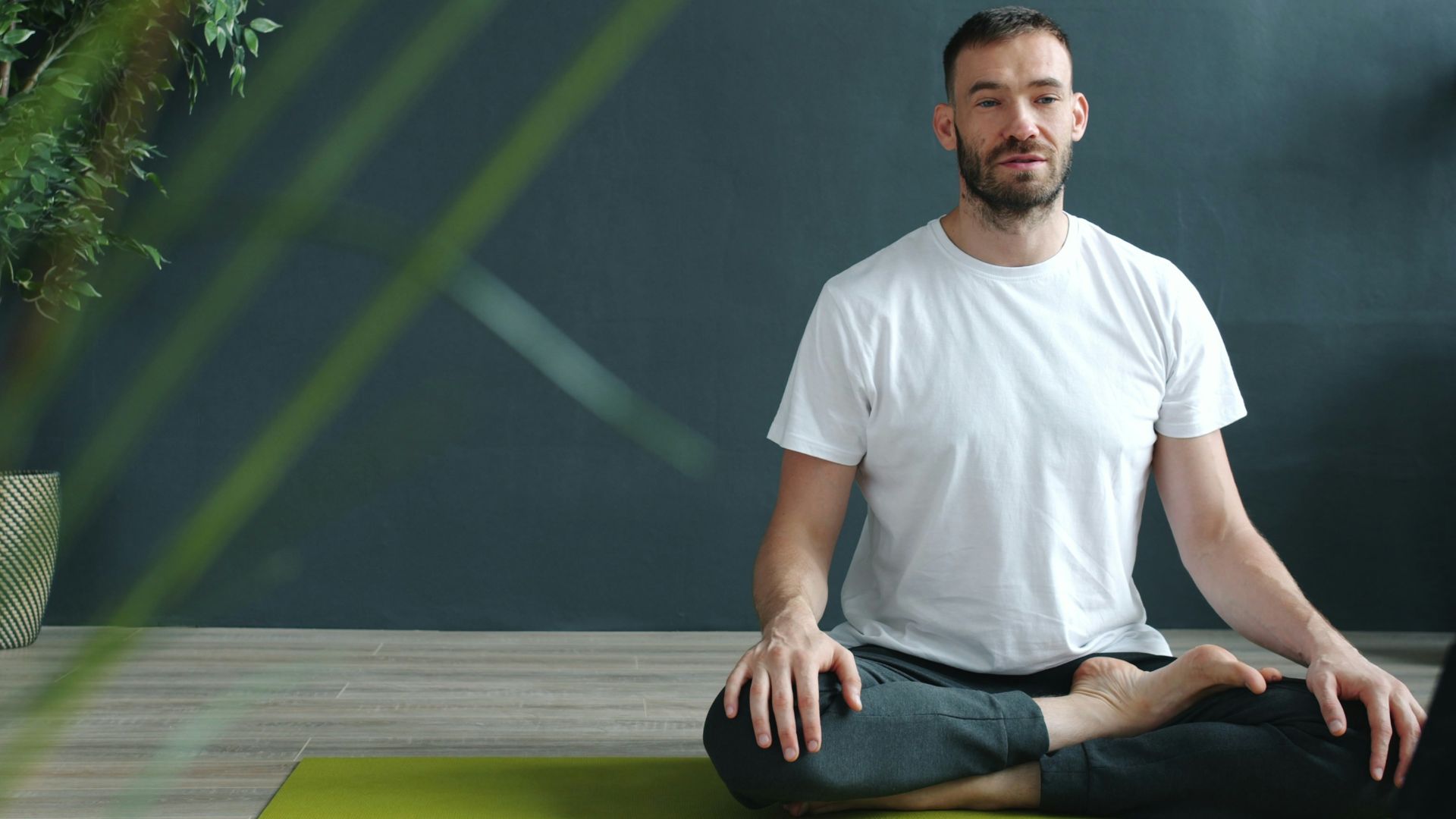 Man meditating in lotus pose on yoga mat