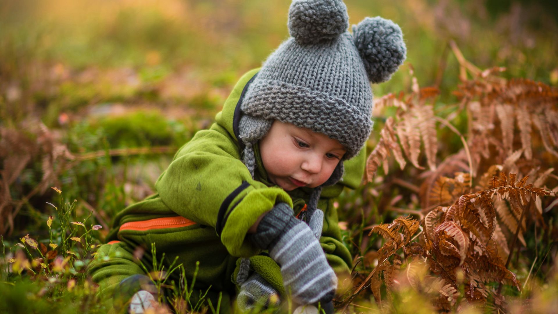 selective focus photo of baby on green grass field