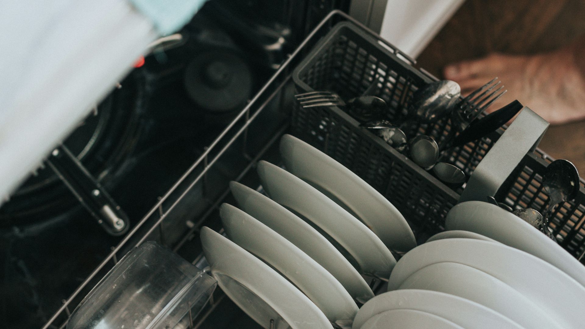 white ceramic plate on black dishwasher
