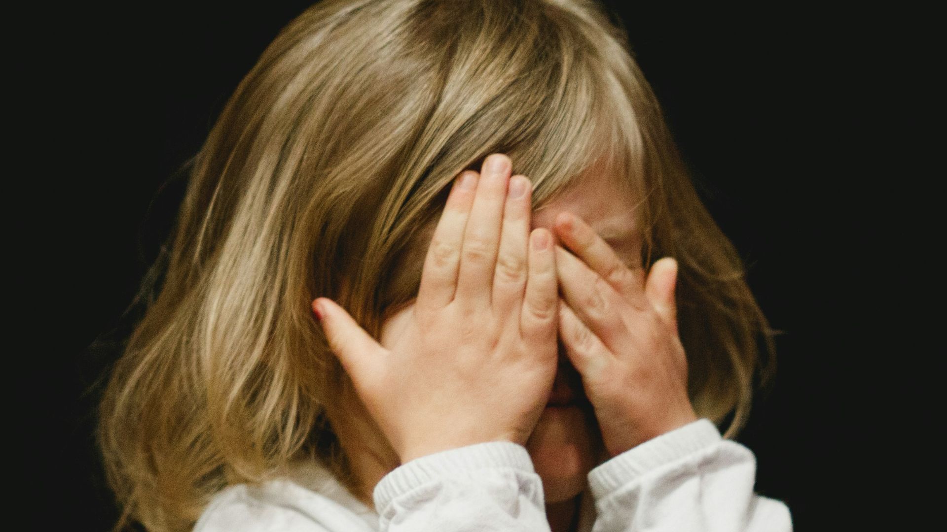 girl covering her face with both hands