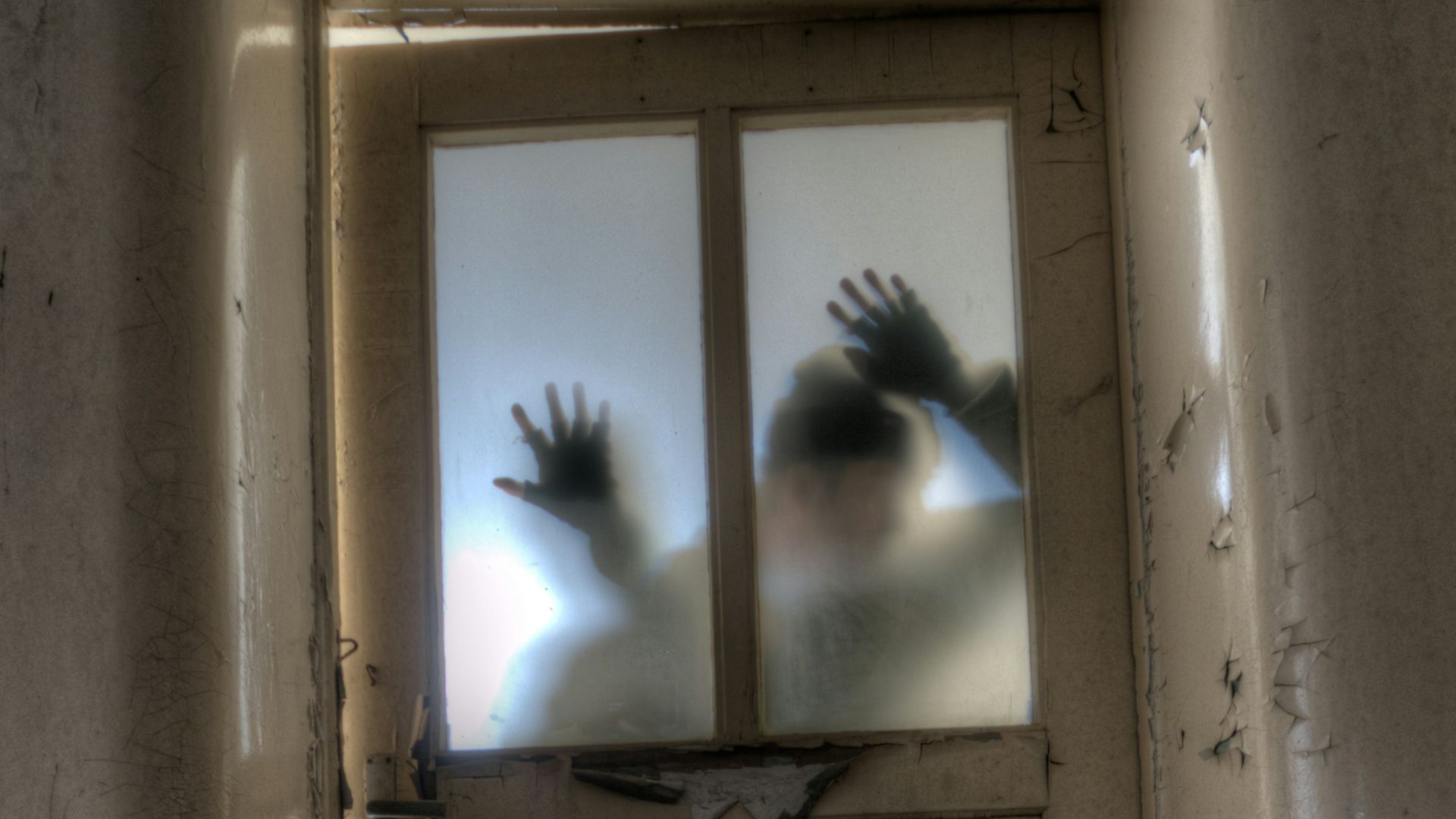 man leaning on frosted glass panel door