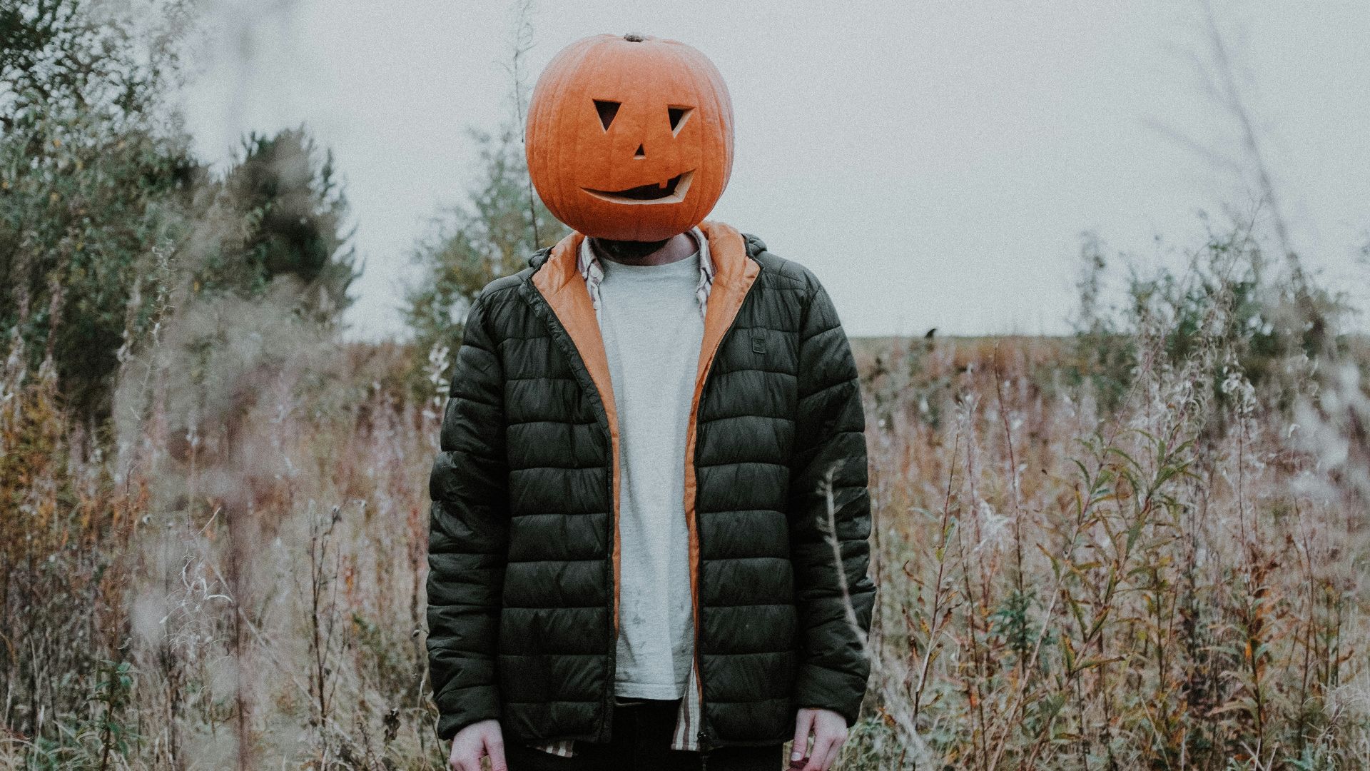 a man standing on top of a grass covered field