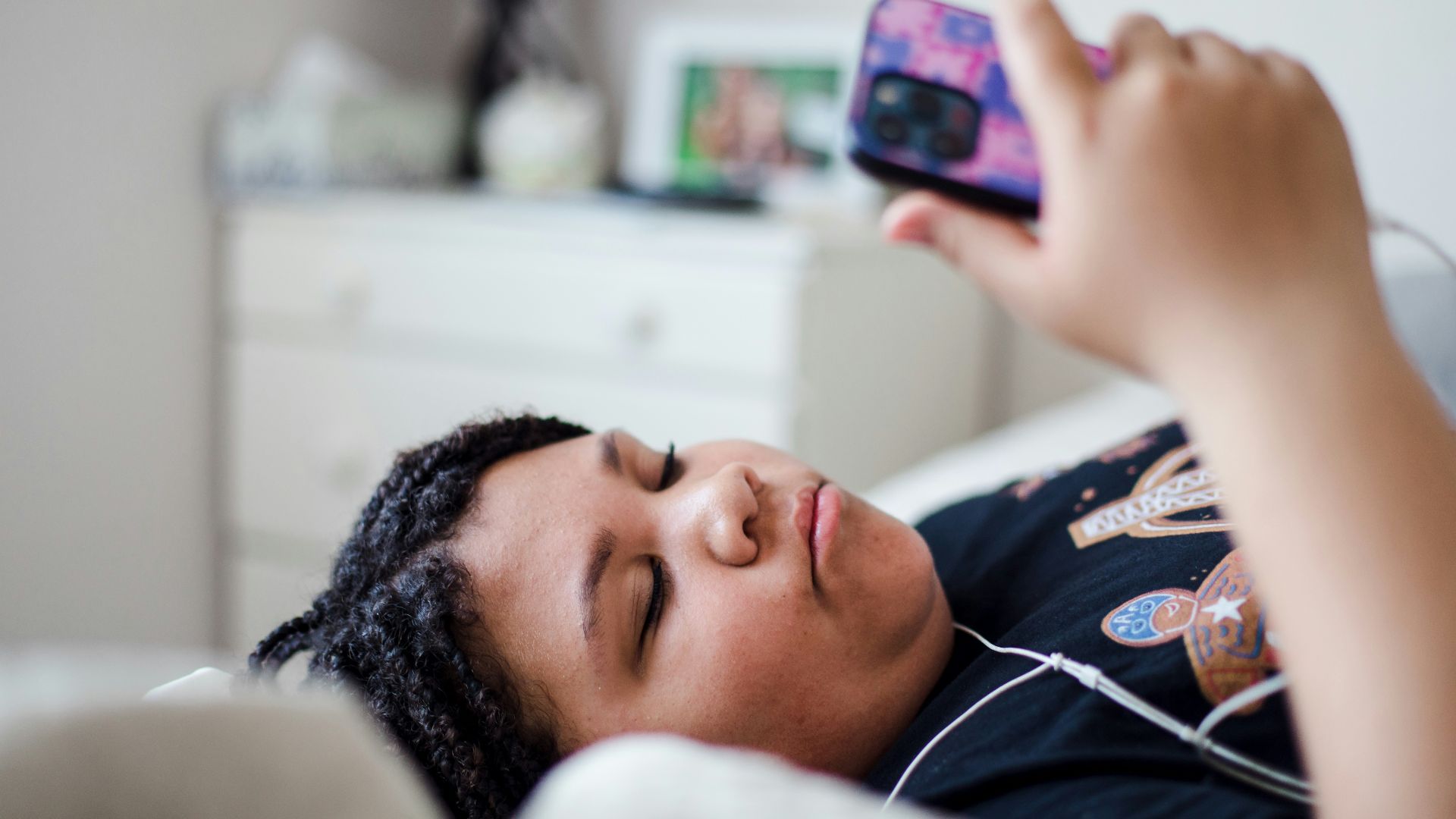 a person laying in bed with a cell phone