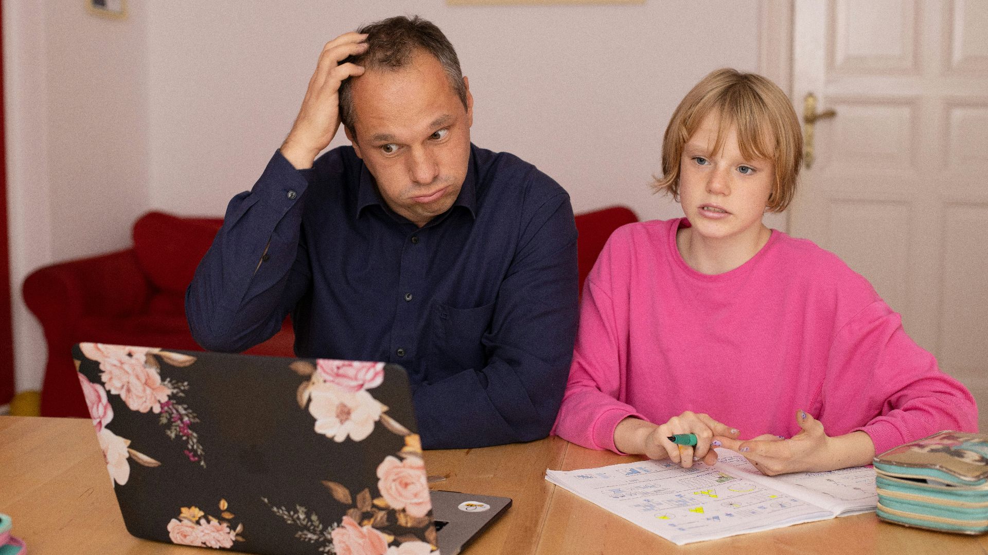 man in blue dress shirt sitting beside girl in pink long sleeve shirt