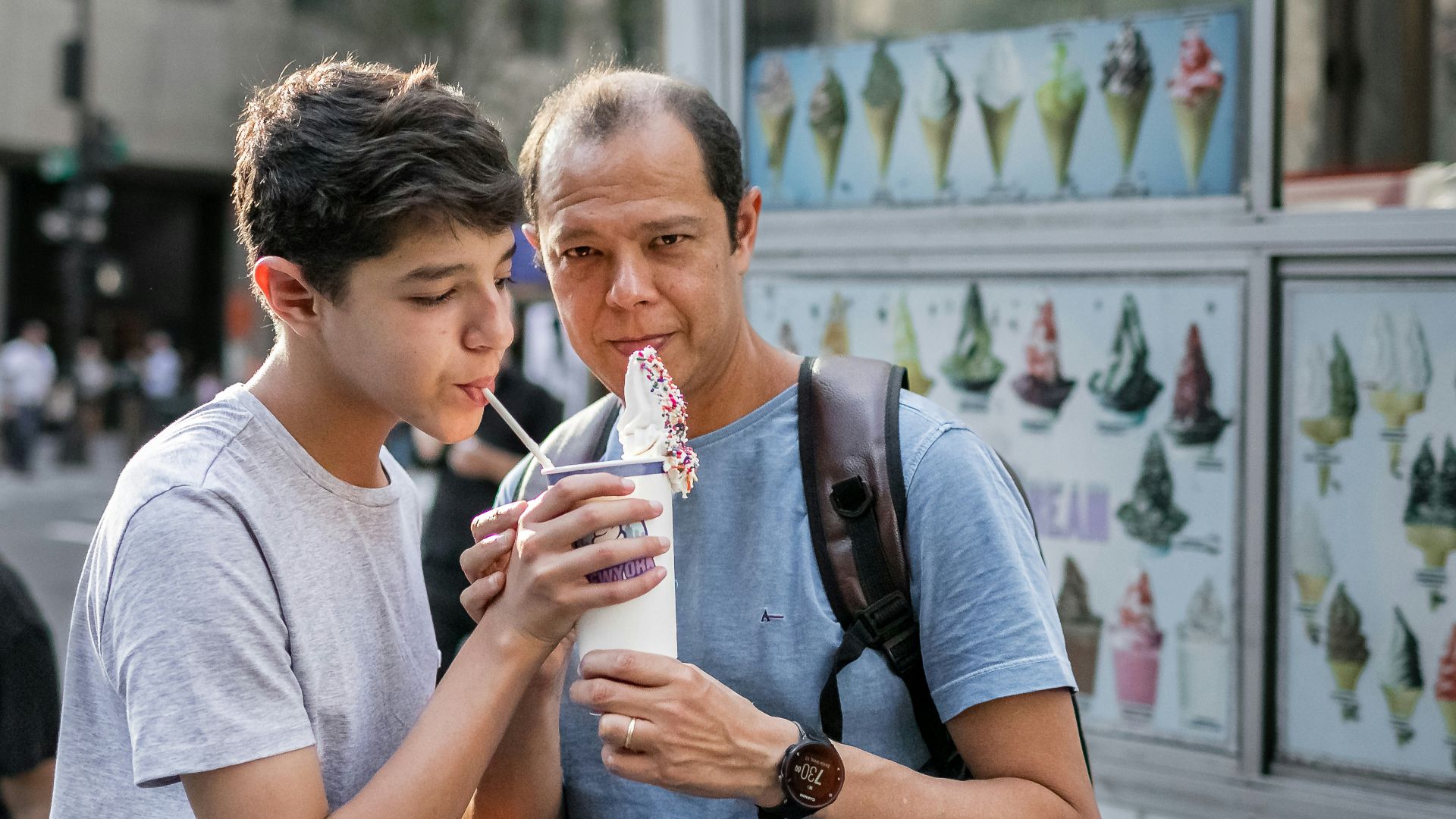 a person holding a drink and another man holding a cup