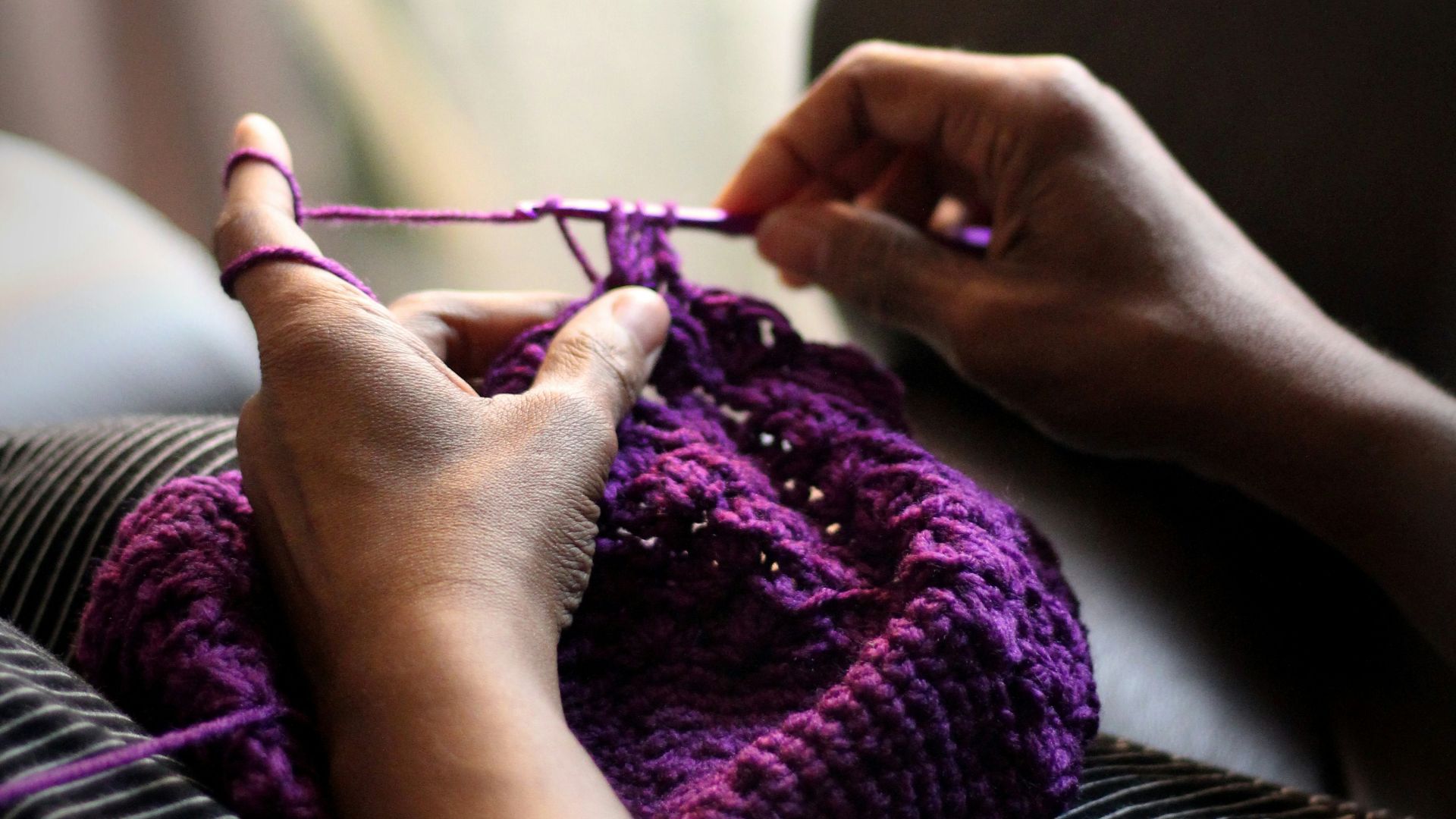 woman sewing purple textile