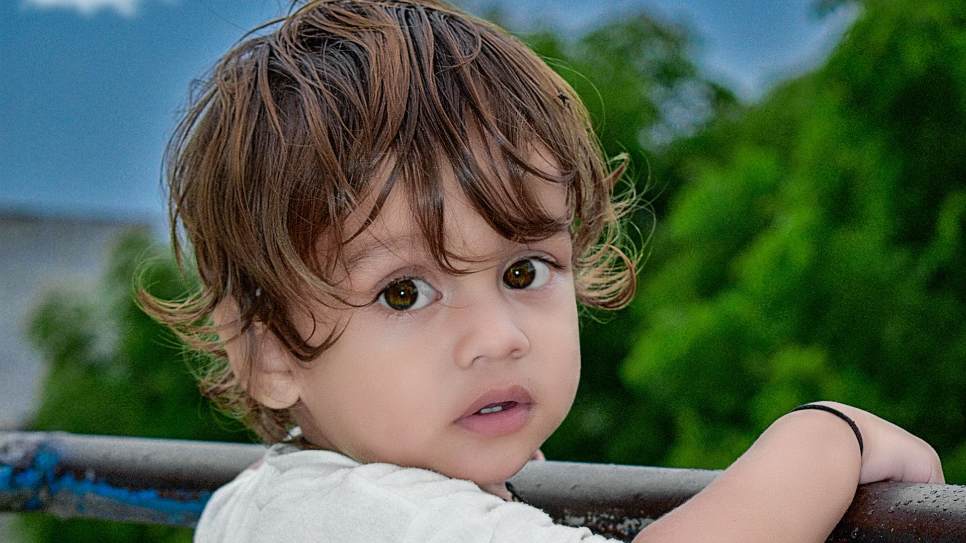 girl in white shirt standing on black metal railings during daytime