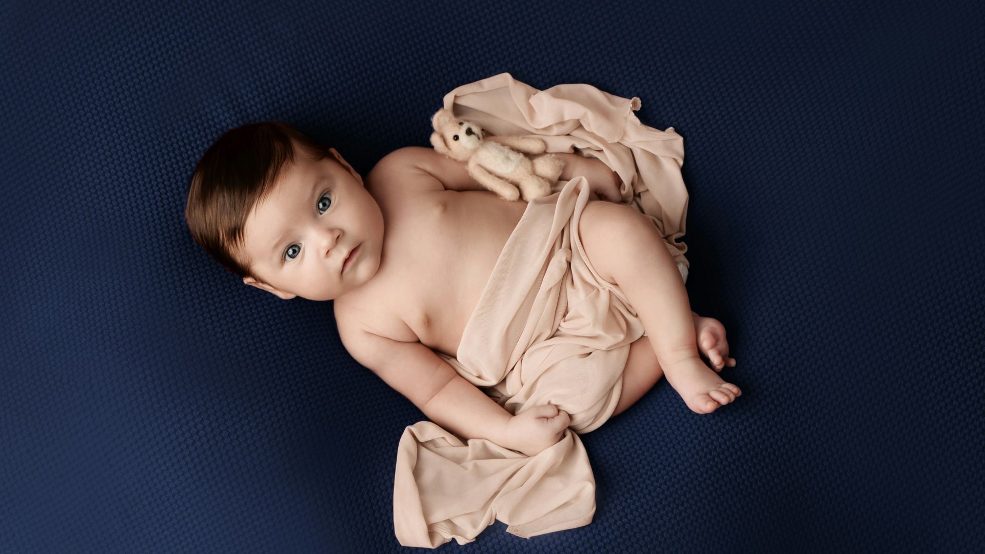 a baby is laying on a blue blanket