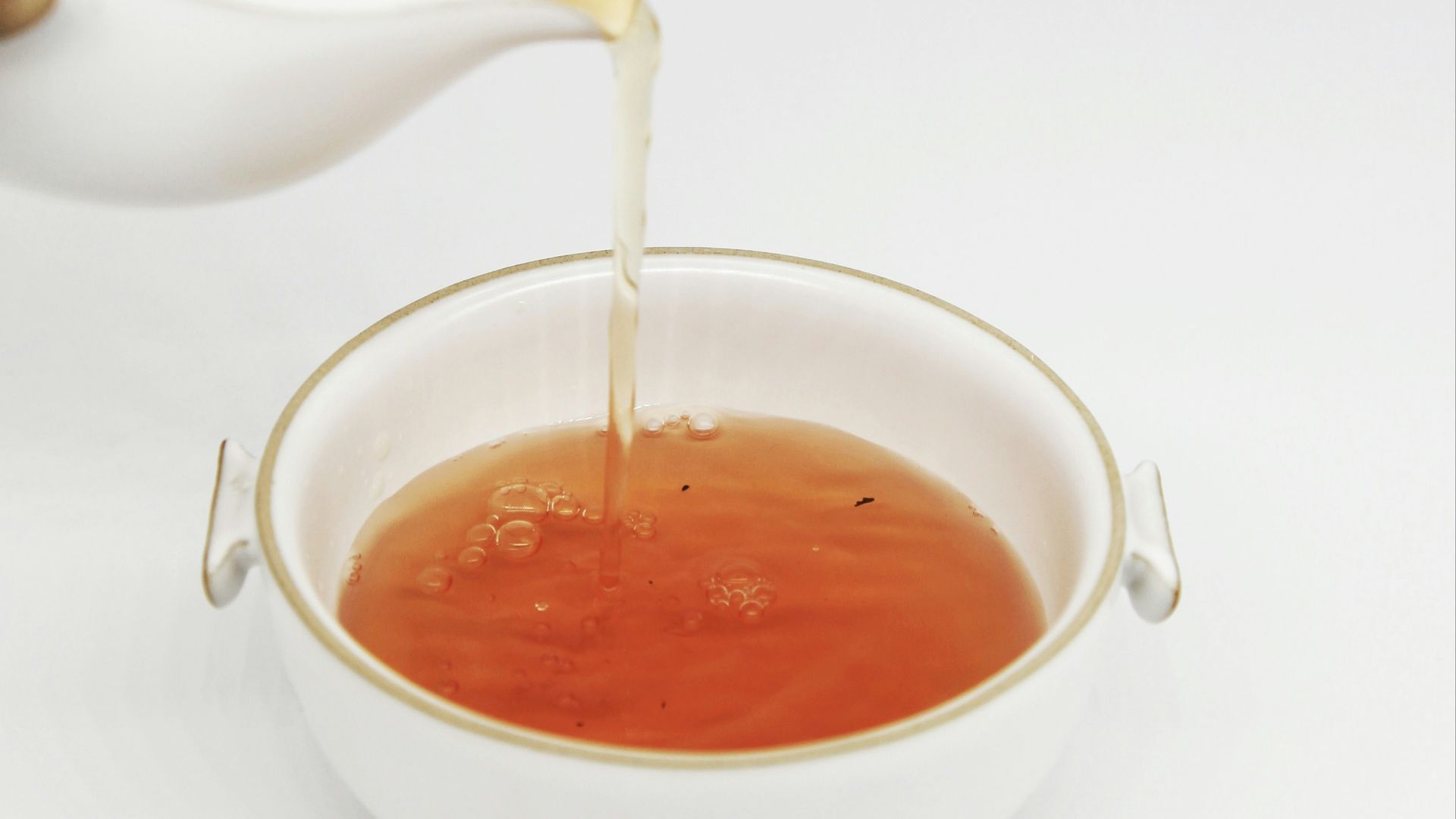 tea pours into white teacup