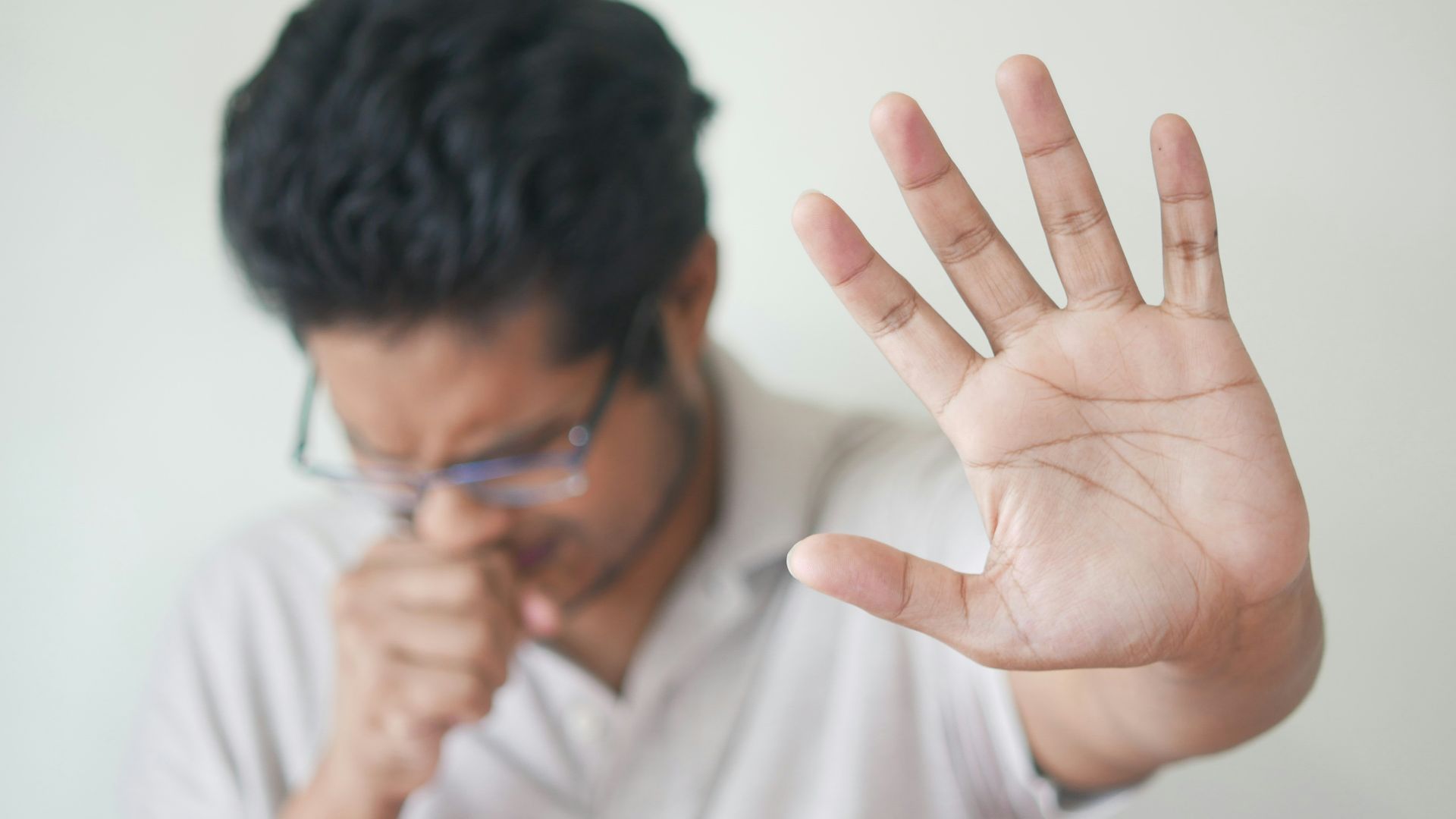 a man holding his hand up in front of his face