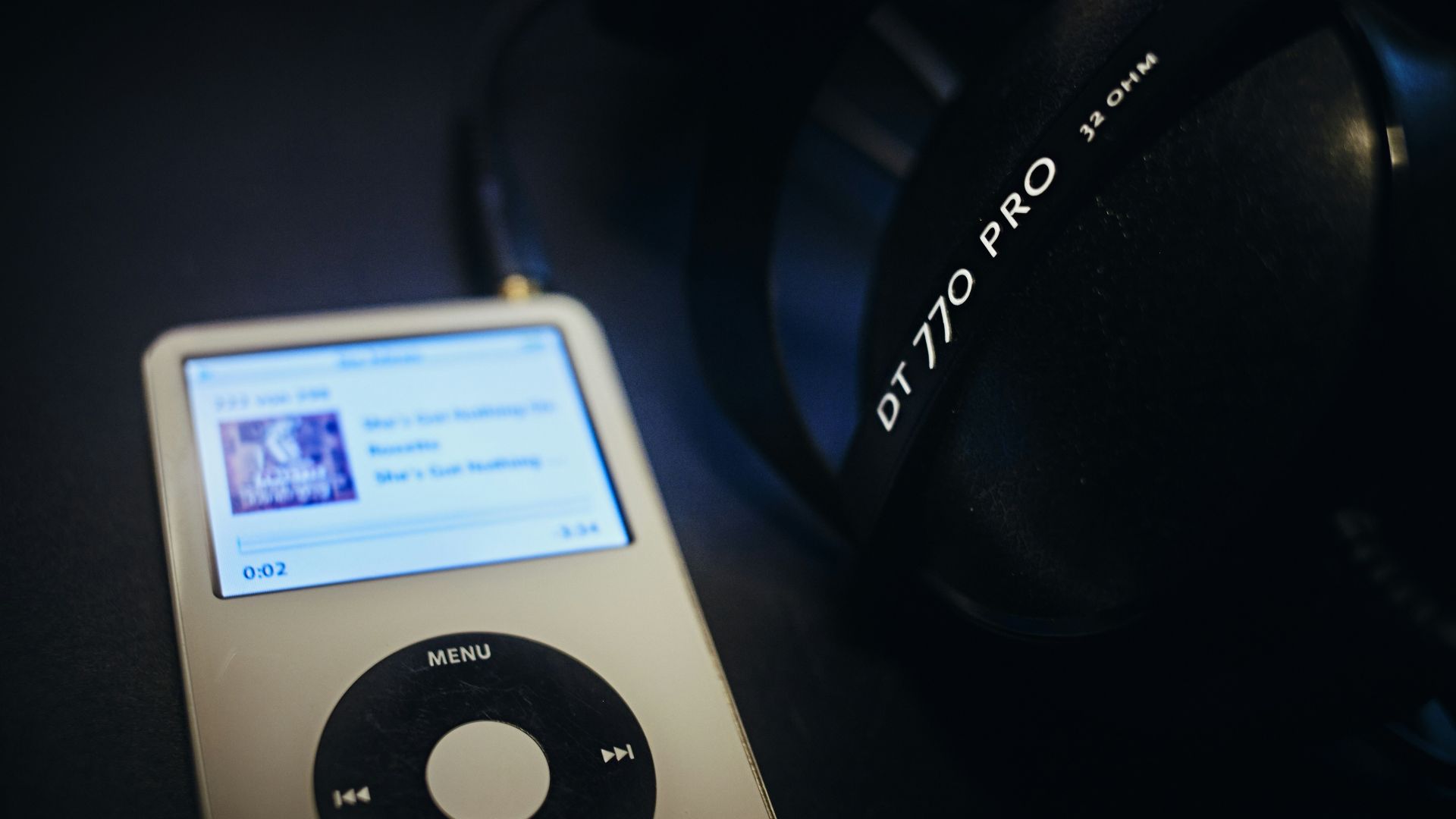 an ipod sitting next to a pair of headphones