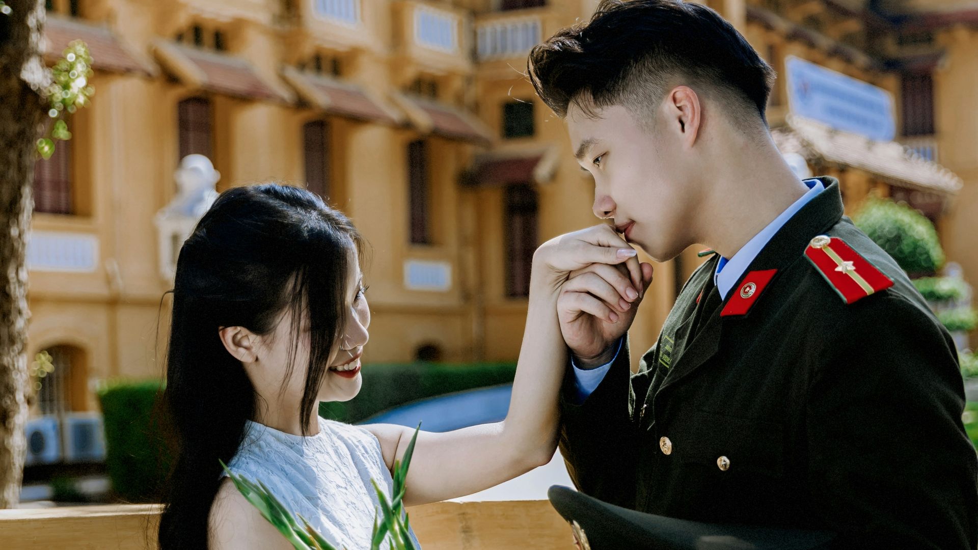 Couple in uniform and dress with flowers