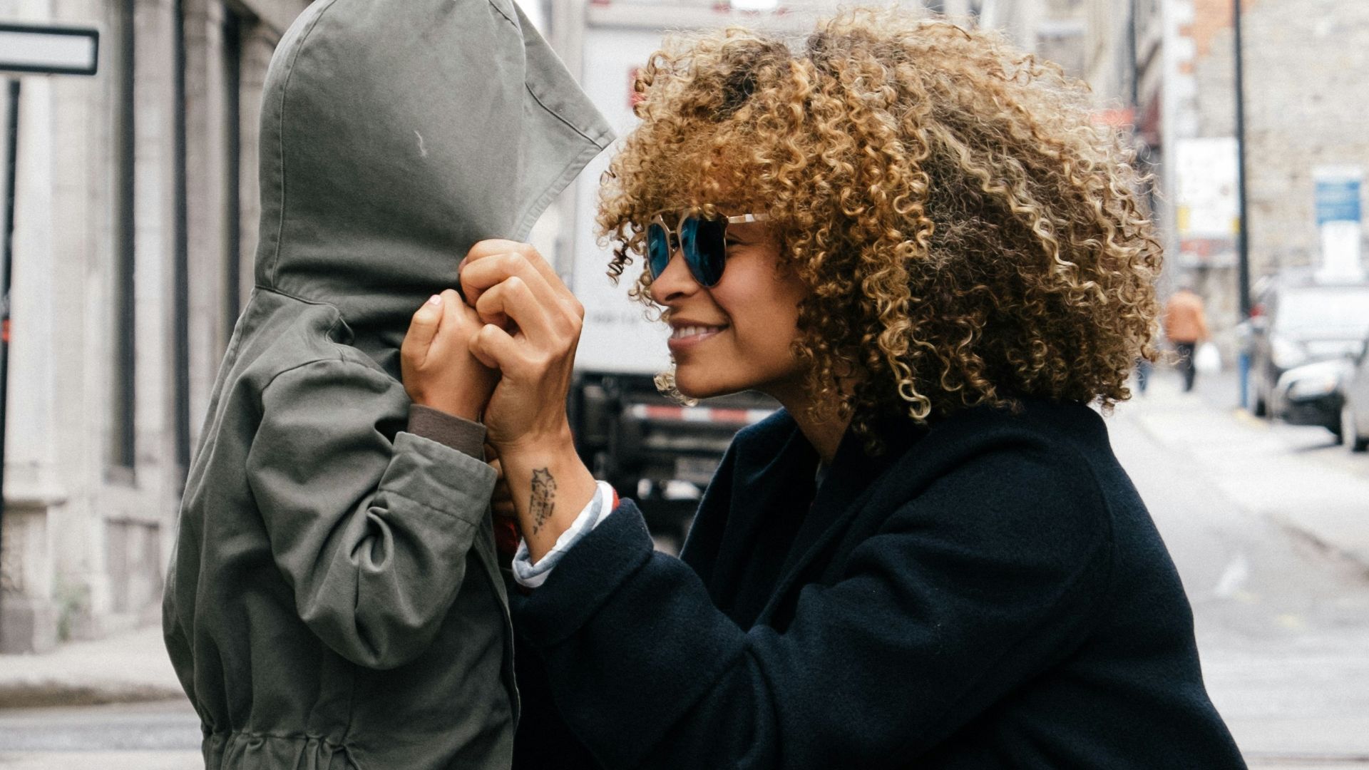 woman holding kid at the street