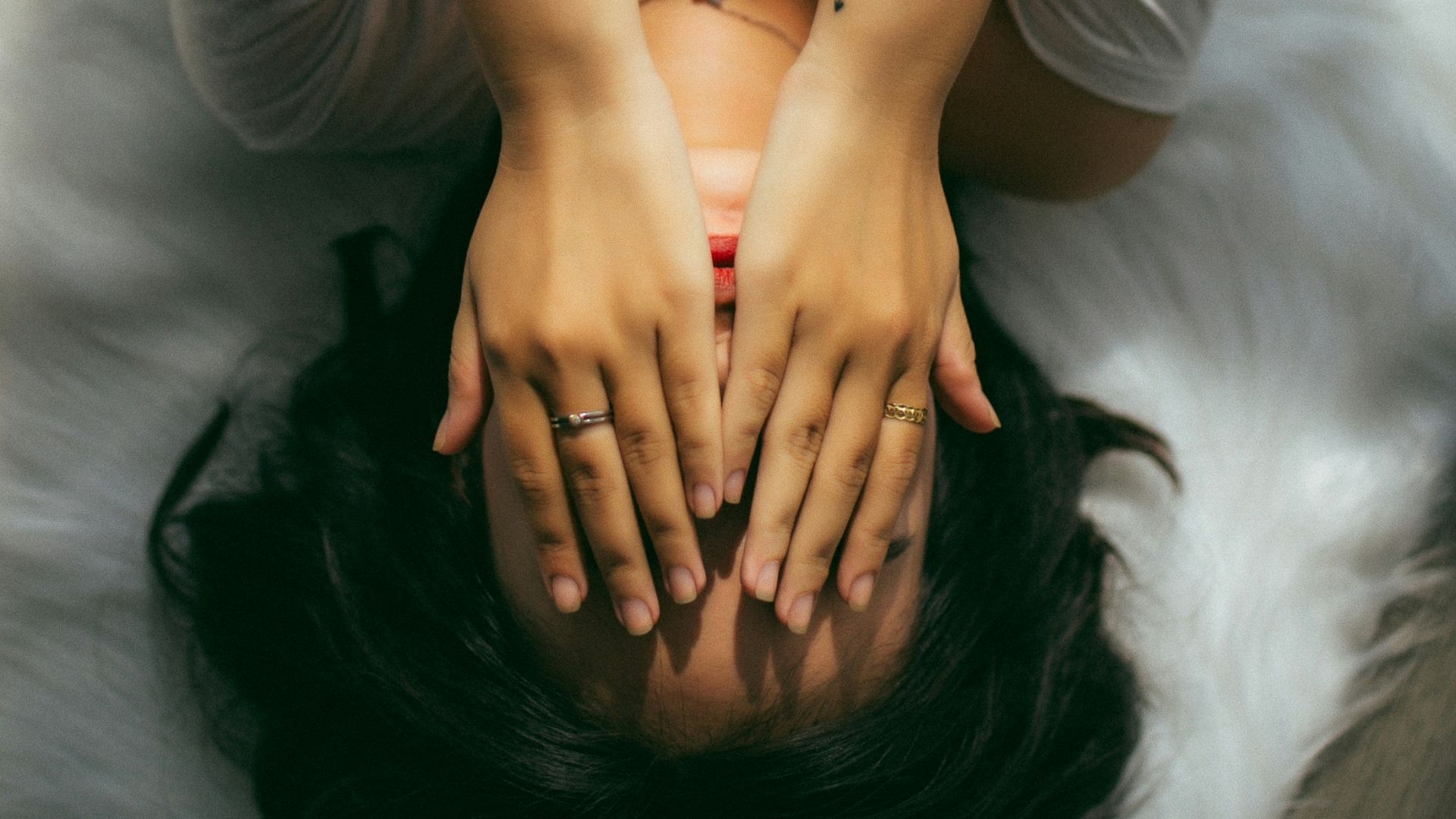 a woman holds her hands over her face