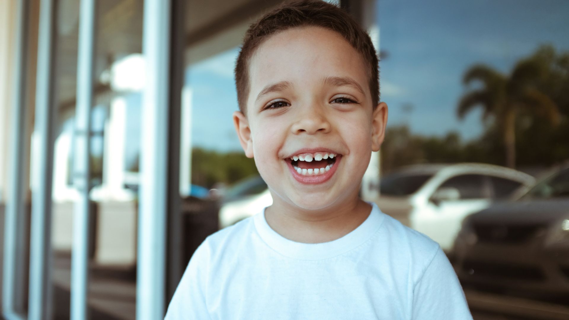 smiling boy wearing white crew-neck t-shirt during daytime