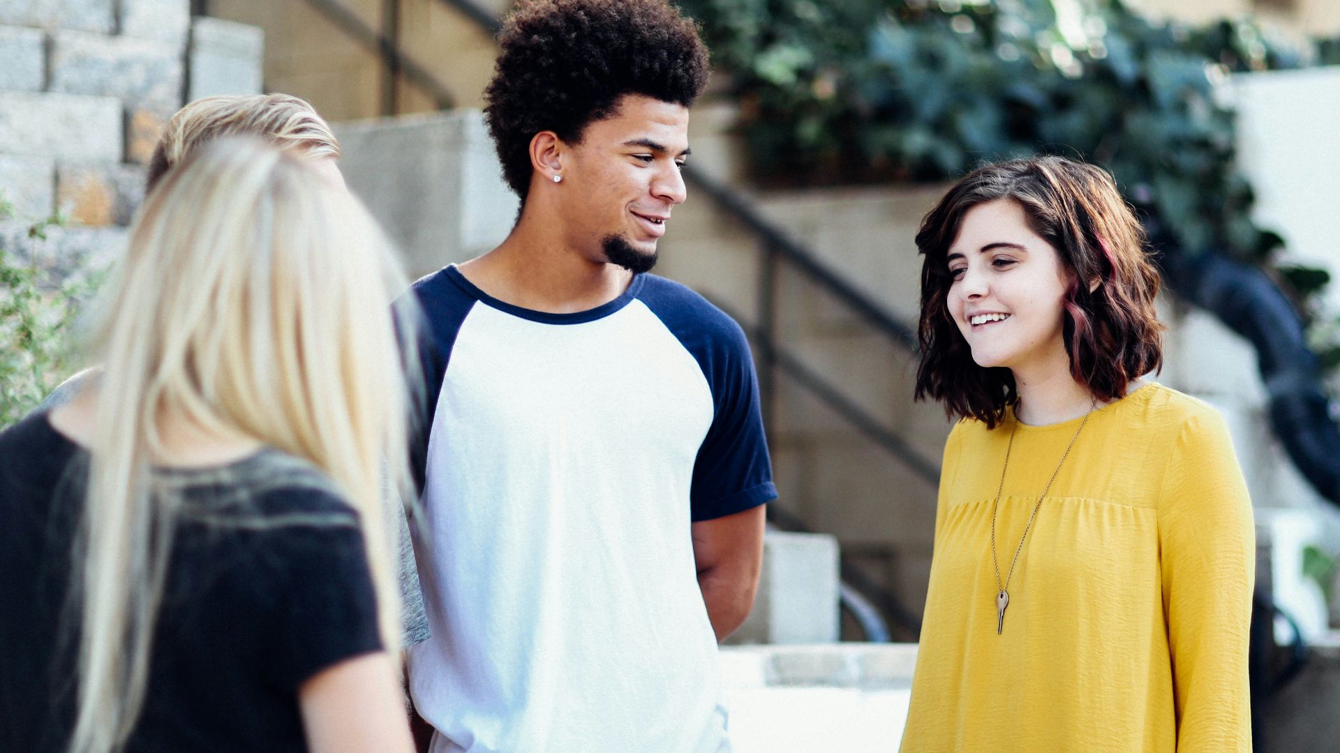 women and man talking outside the building