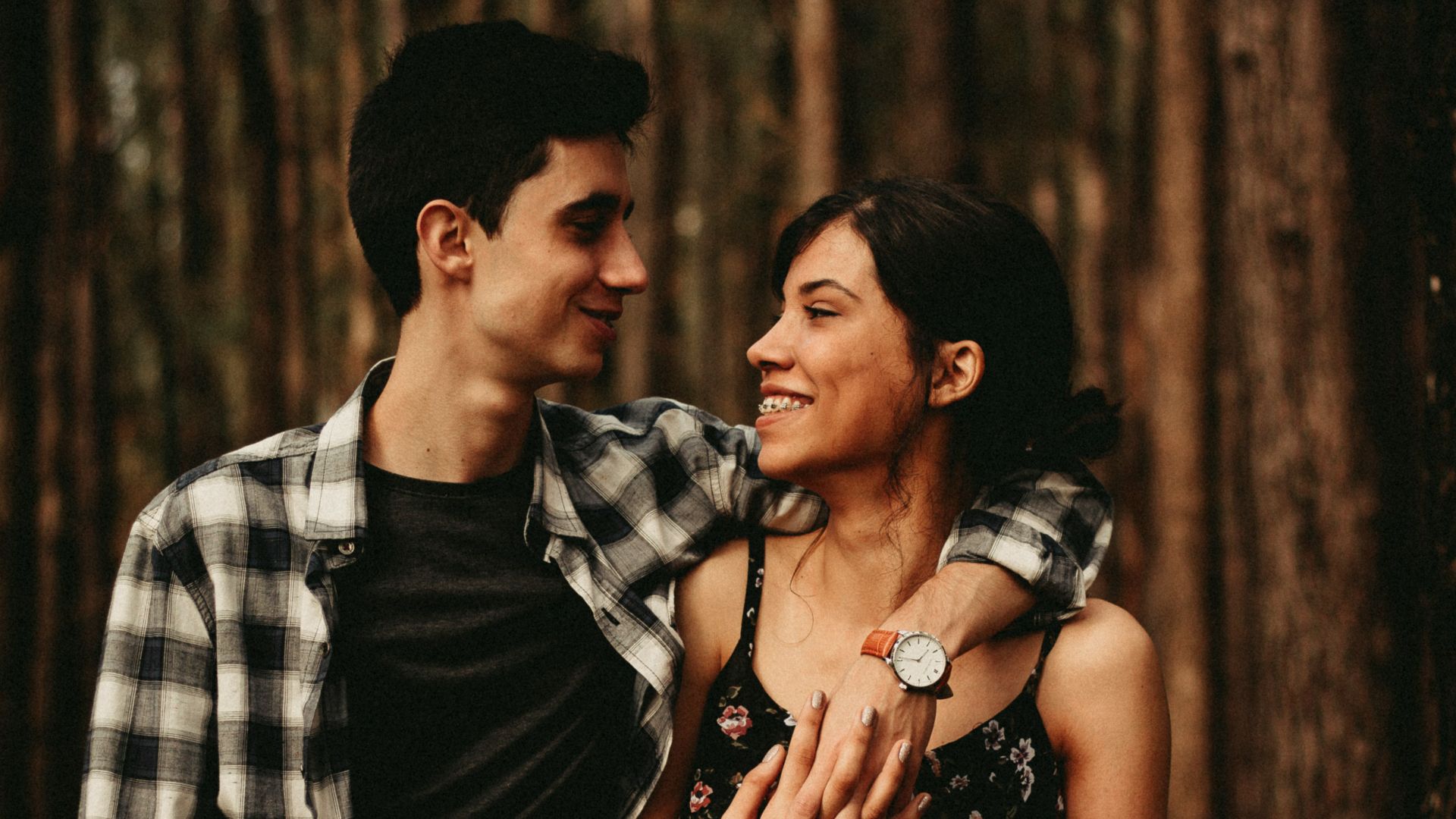man wrapping arm on woman facing each other