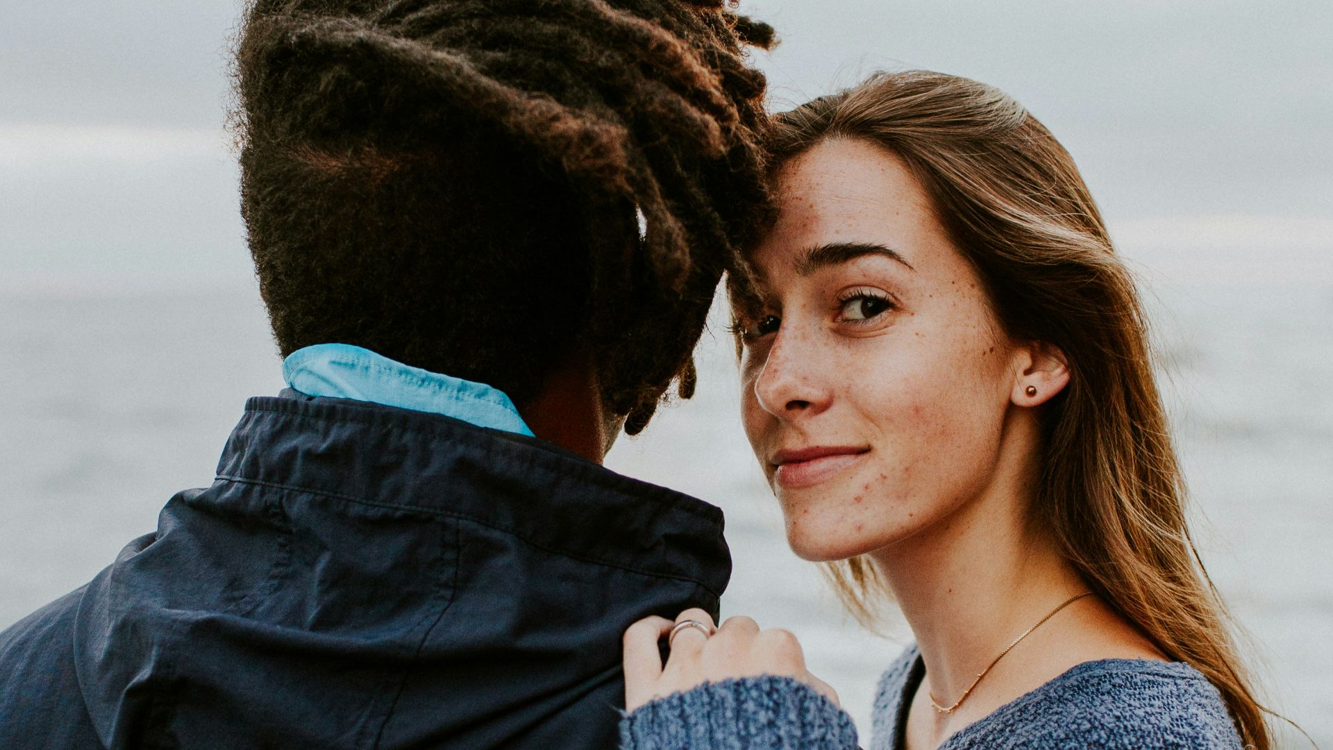 woman in blue long sleeve shirt beside woman in gray long sleeve shirt