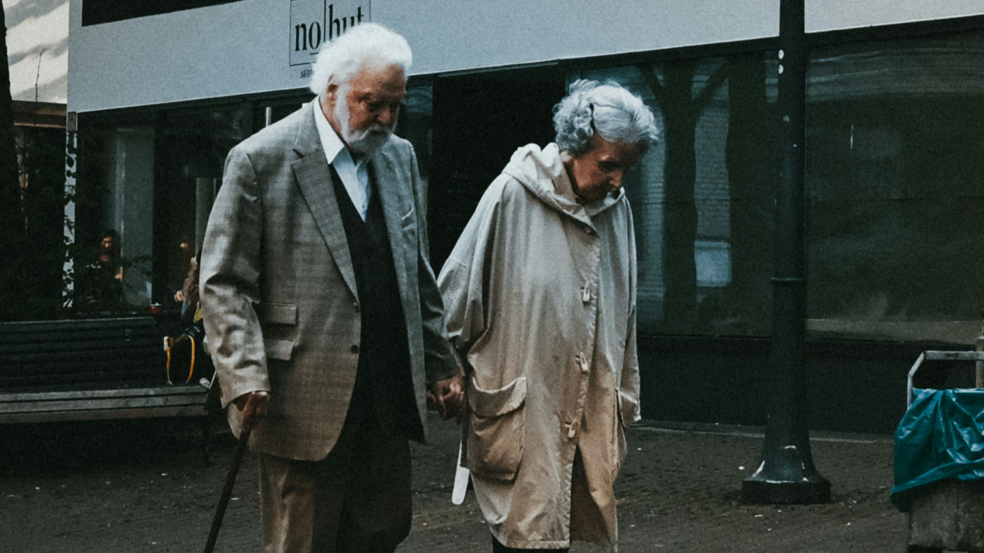 man in black suit standing beside woman in white coat