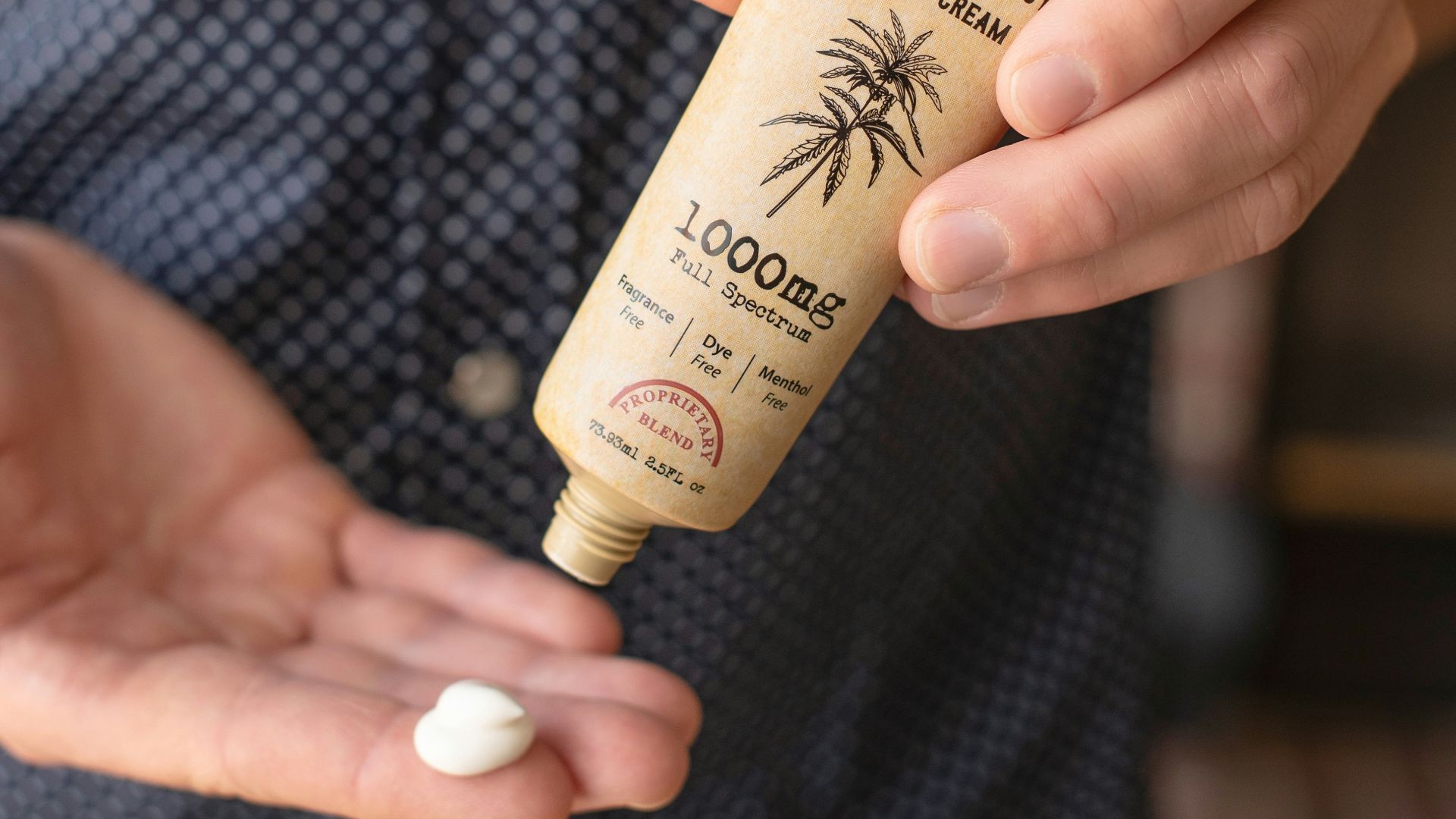 person holding white and gold tube bottle