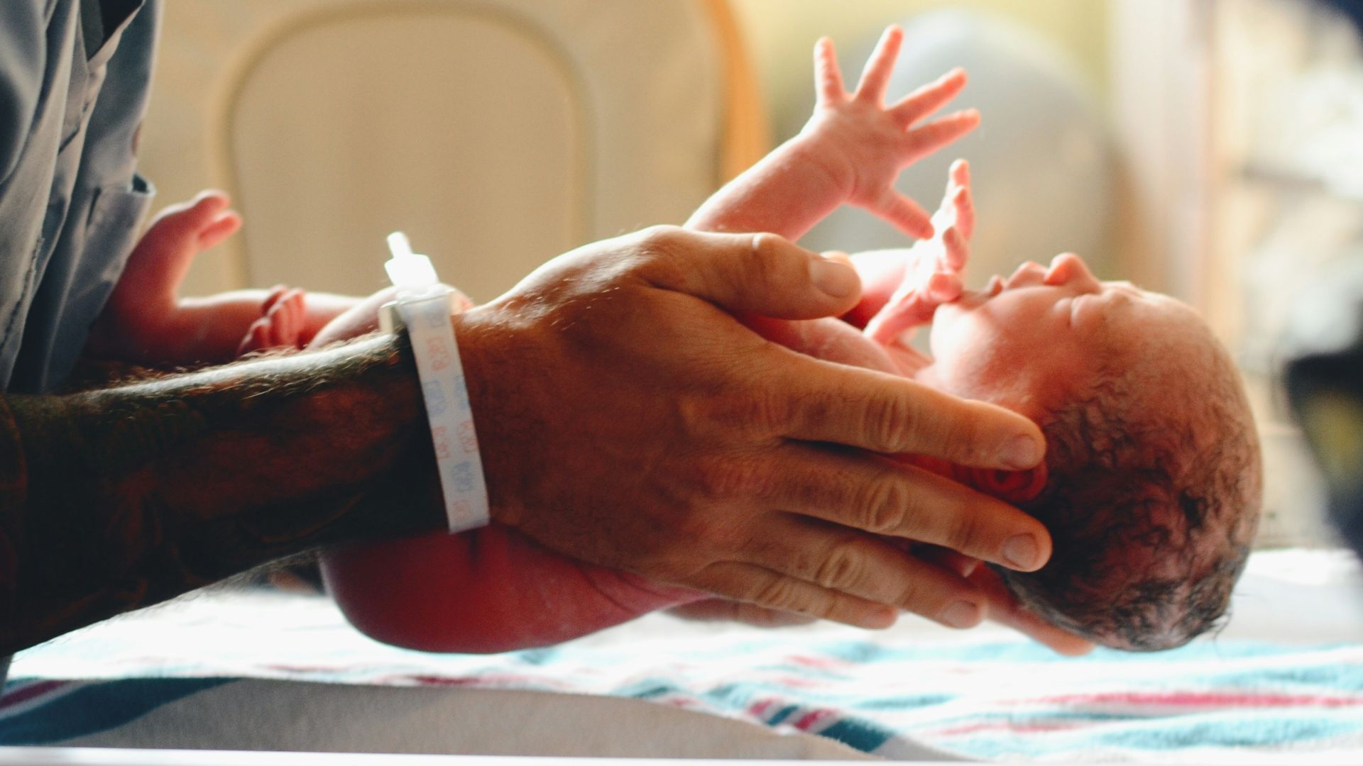 person wearing gray shirt putting baby on scale