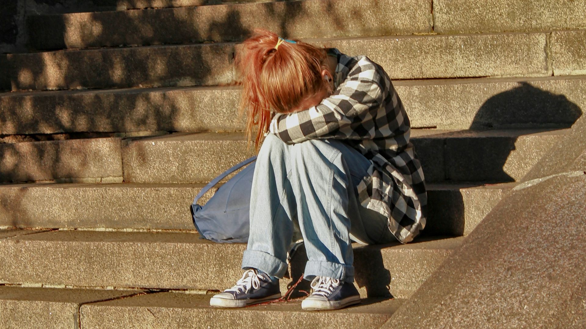 woman in black and white dress sitting on concrete stairs